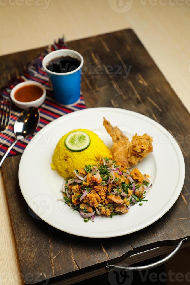 heiß Zitrone Hähnchen Reis Mahlzeit serviert im Teller mit Soße, kalt trinken, Löffel und Gabel isoliert auf hölzern Tafel Seite Aussicht von thailändisch Essen foto