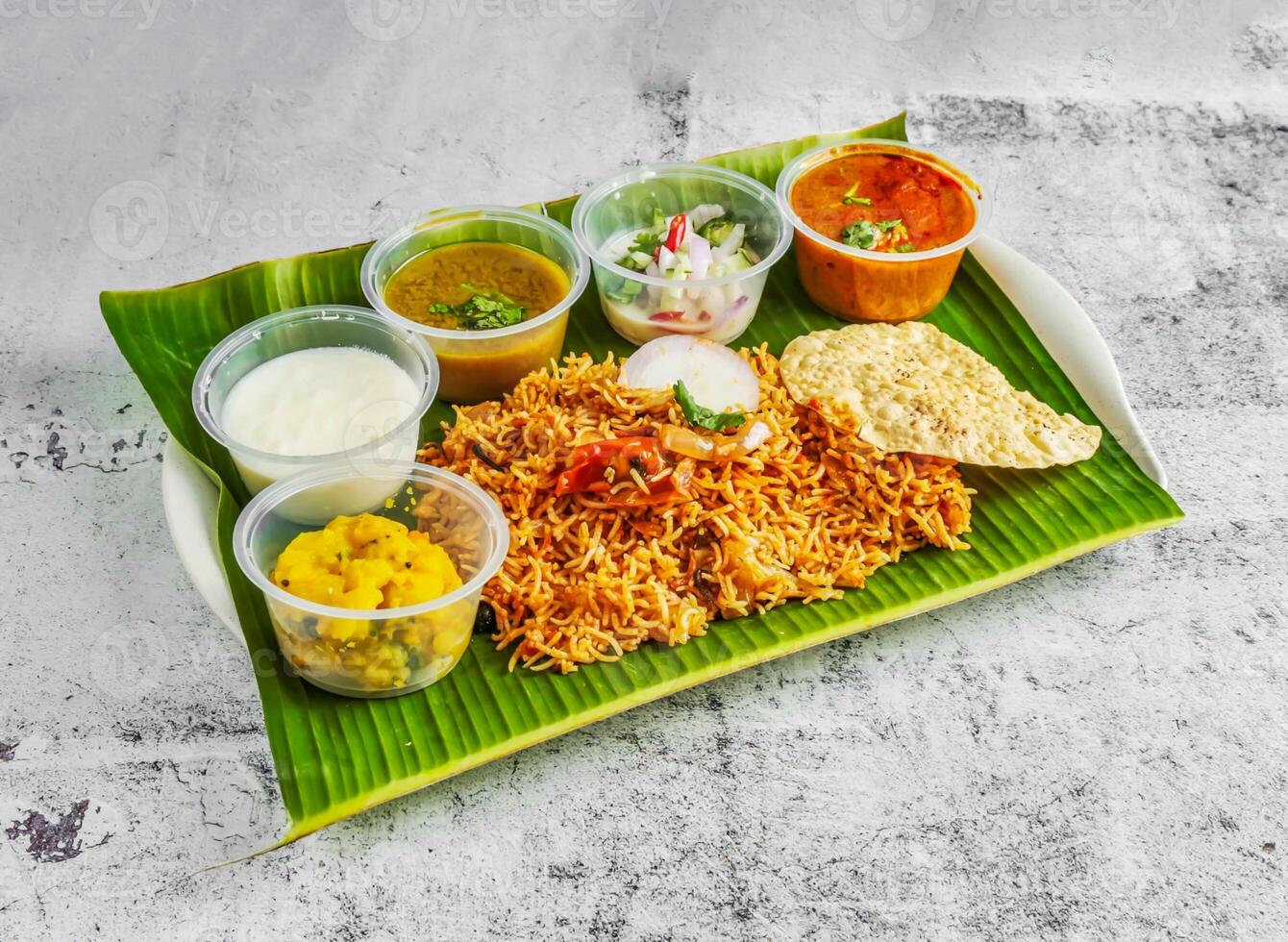 Gemüse Briyani mit Salat, Chutney, Raita und Soße serviert im Gericht isoliert auf Banane Blatt oben Aussicht von indisch und Singapur würzig Essen foto