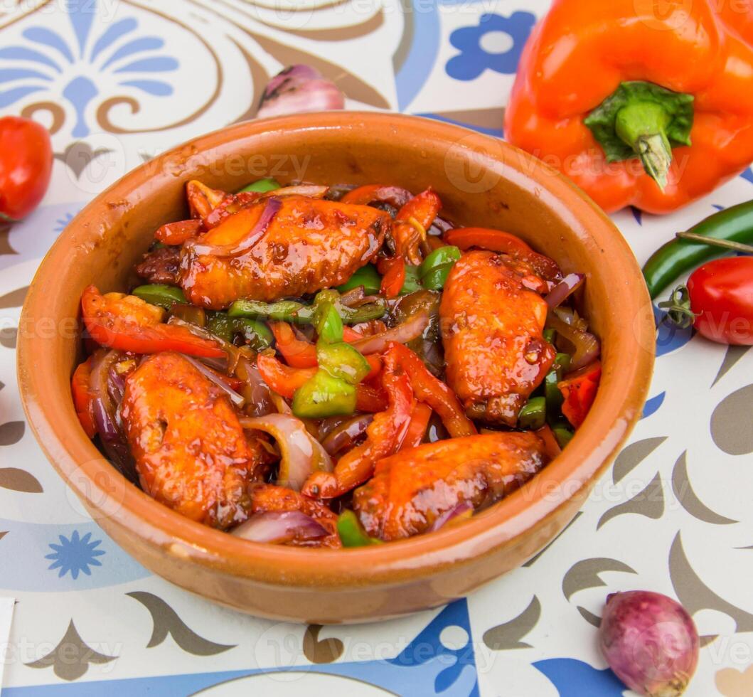 Fachara Hähnchen Flügel mit Tomate, Zwiebel und Glocke Pfeffer serviert im Gericht isoliert auf Tabelle oben Aussicht von Arabisch Essen foto