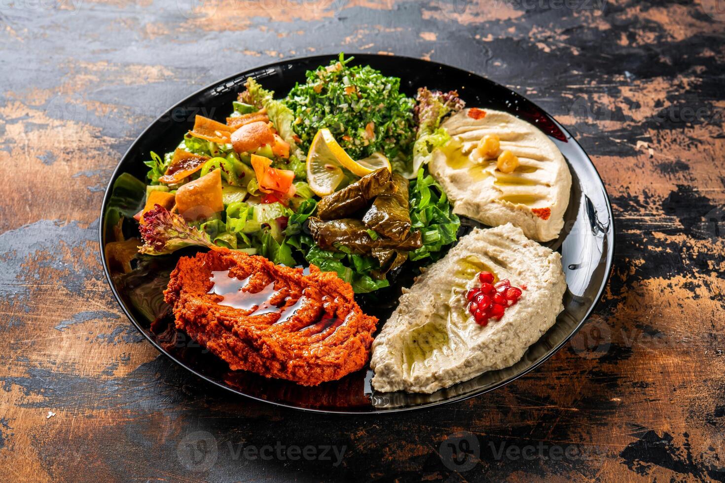 Mezze Teller oder mezzeh Hummus, Ranke Blätter, Tabouleh, baba Ganoush, Zitrone, veränderlich serviert im Gericht isoliert auf Hintergrund oben Aussicht von Arabisch Essen foto