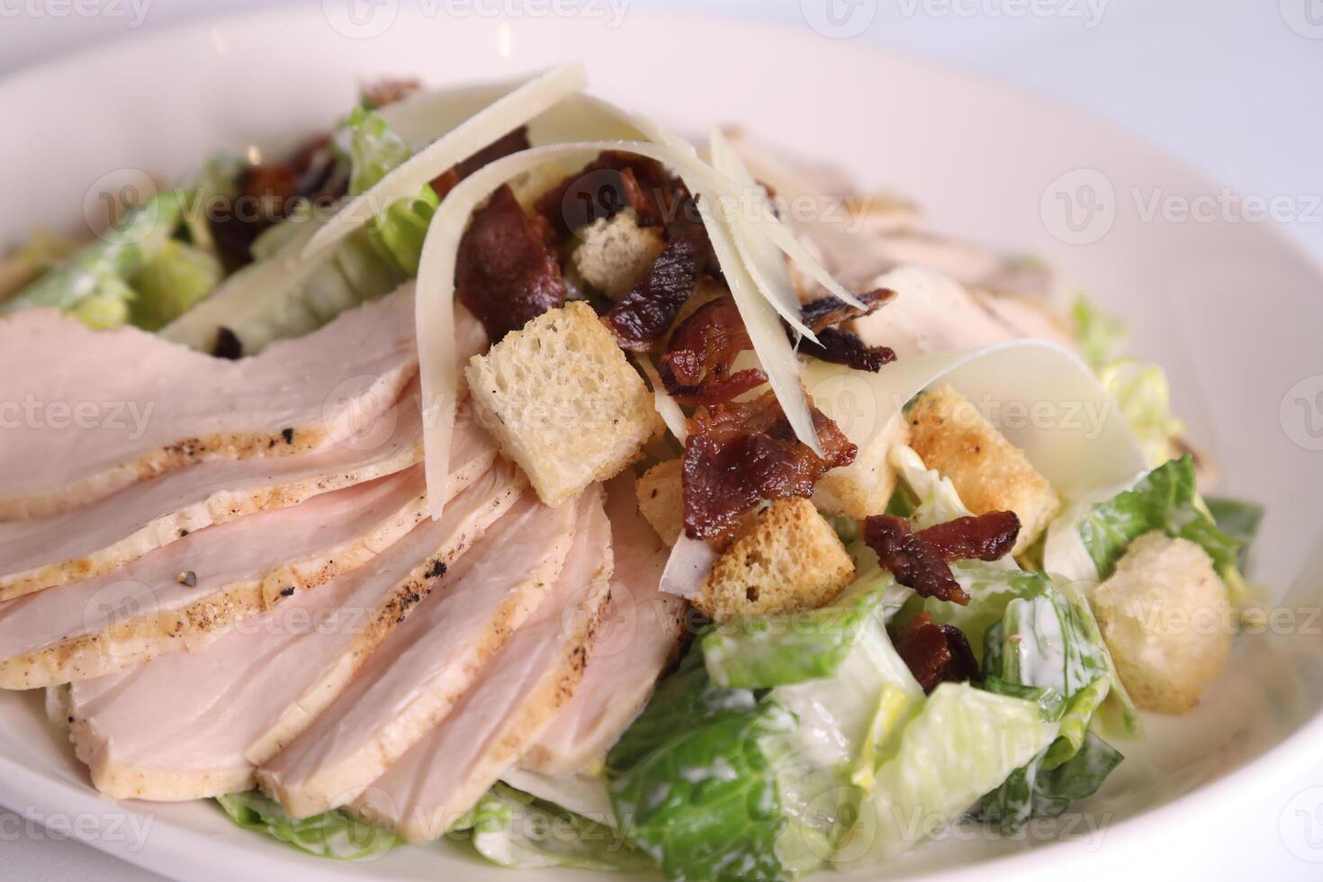 klassisch Caesar Salat Nahansicht mit Kohl, Hähnchen Scheibe, Olive, Brot und Grün Blatt serviert im Teller isoliert auf Tabelle Seite Aussicht von Arabisch gesund Salat foto