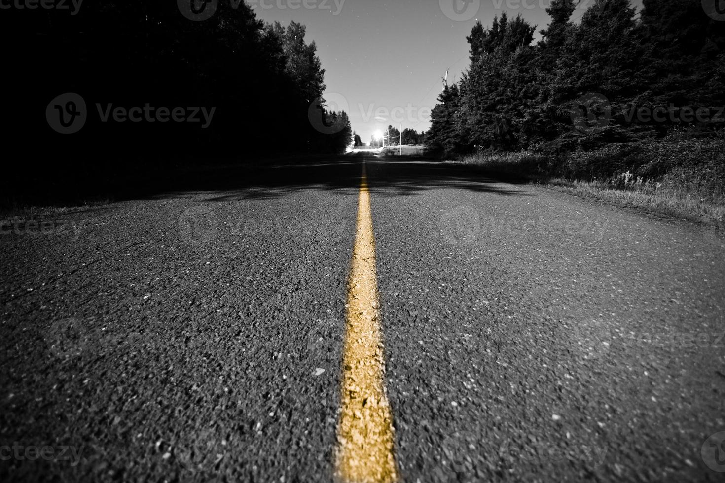 leere Straße mit gelber Trennlinie in der Nacht foto