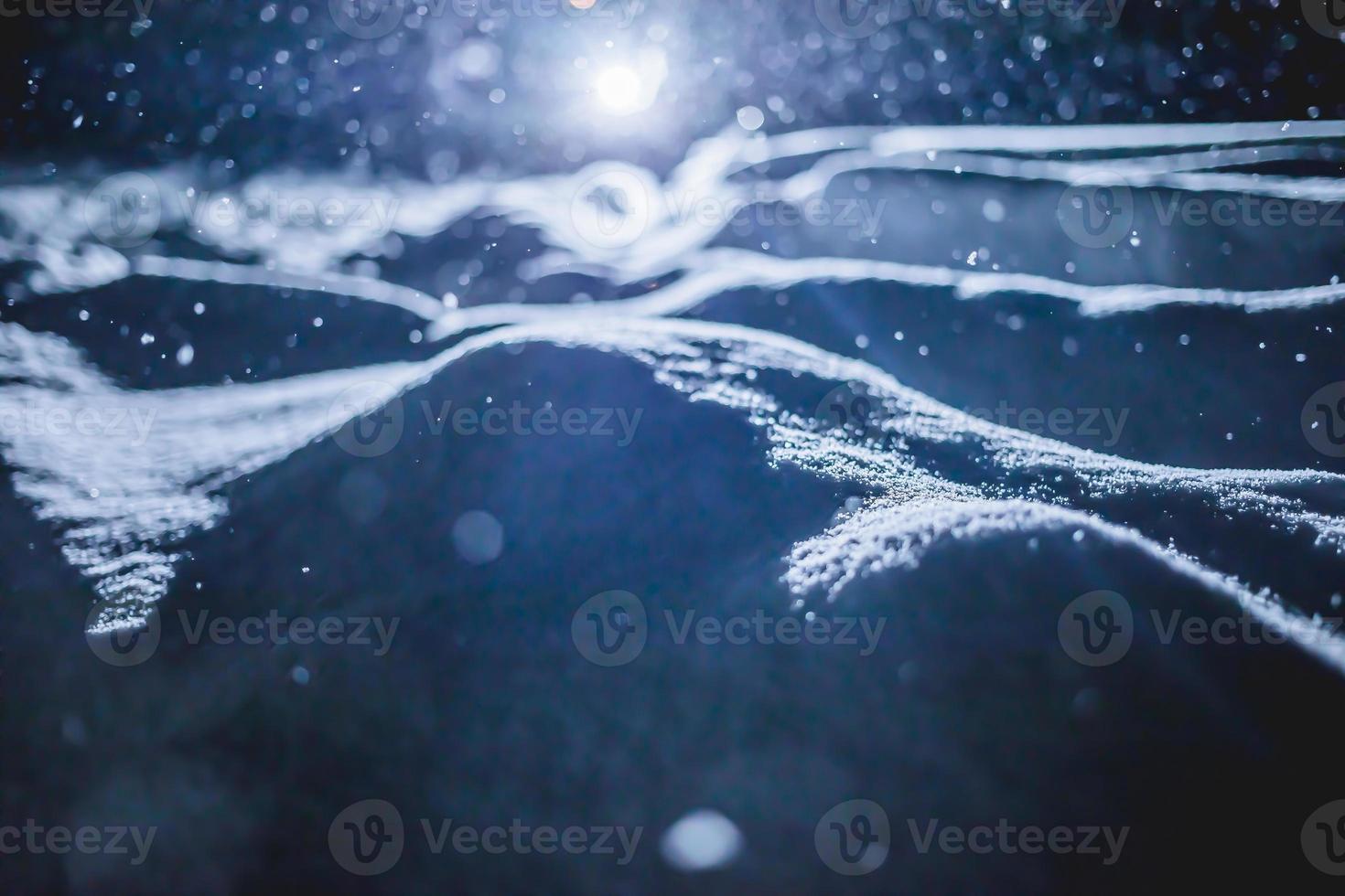 hintergrundbeleuchtete schneebeschaffenheit bei schneesturm in der nacht foto