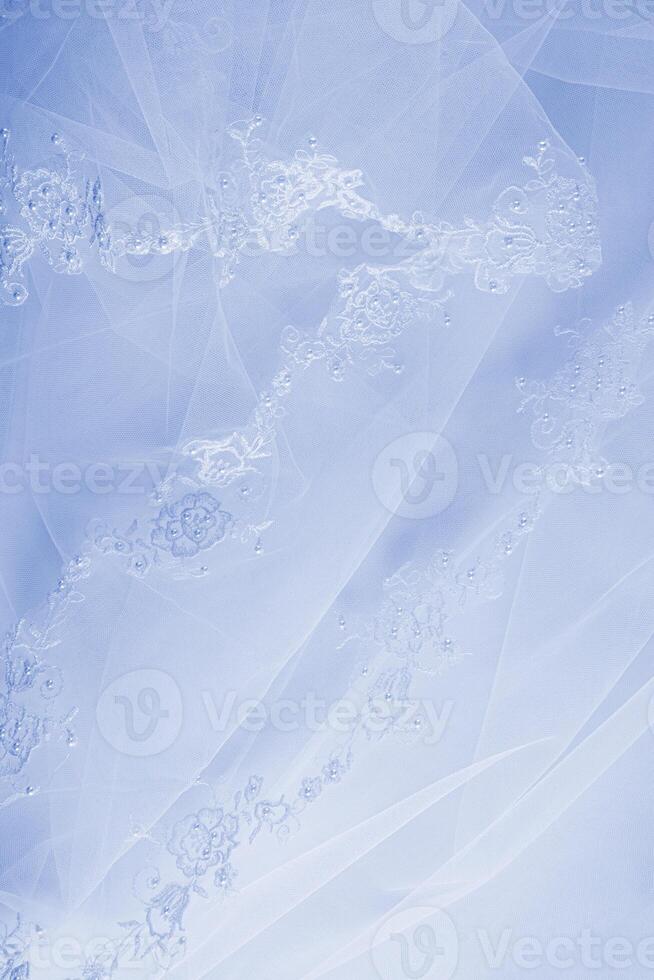 Teil von ein schön Blau Stickerei Spitze Tüll Stoff oder Teil von ein Braut Hochzeit Kleid auf ein Blau Satin- Hintergrund. Raum zum Text. Design Vertikale foto