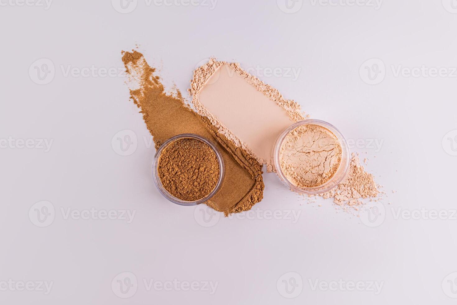 oben Aussicht von zwei Glas Gläser mit trocken Pulver im Beige und Bronze- Farbe Stehen auf Pulver Farbfelder. Weiß Hintergrund. Layout. Produkt Werbung. foto