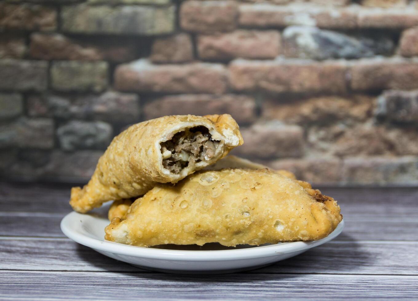 typisch Argentinien gebraten Fleisch Empanadas, auf rustikal Hintergrund foto