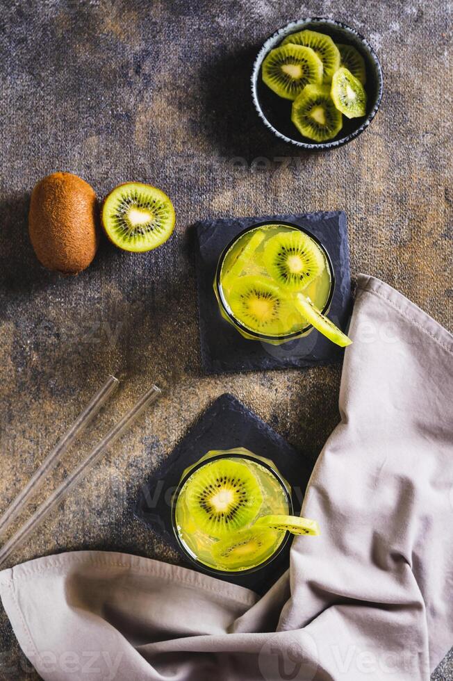 erfrischend tropisch trinken Mojito mit Kiwi im Brille auf das Tabelle oben und Vertikale Aussicht foto