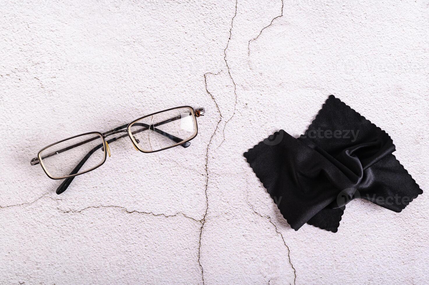 alt gebrochen gebrochen Brille und Stoff auf grau Hintergrund oben Aussicht foto