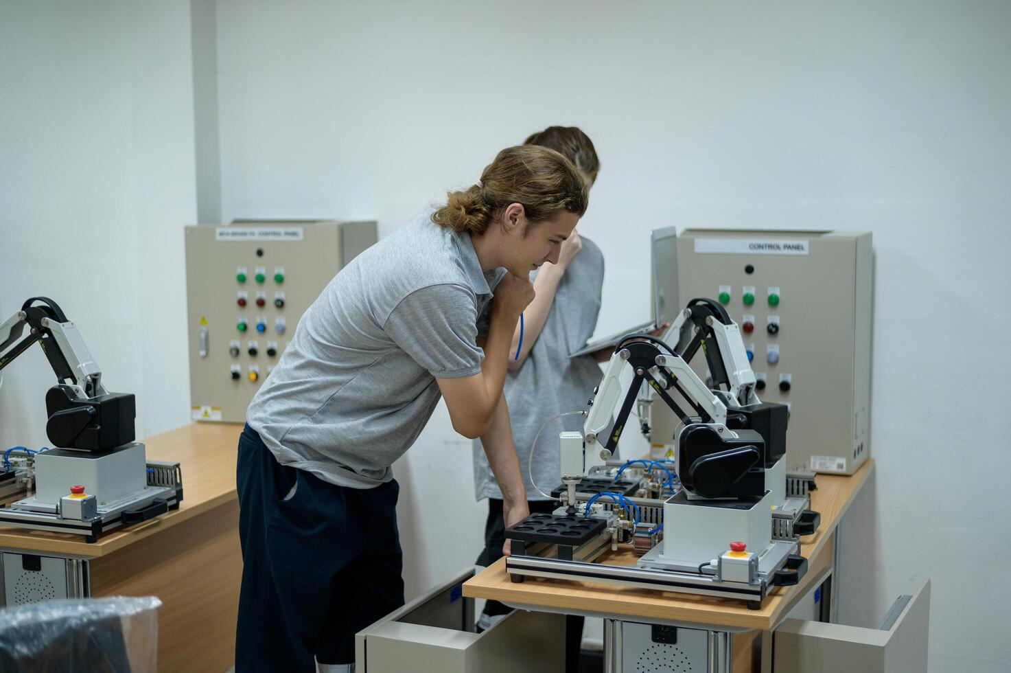 Auszubildender Robotik Ingenieur Lernen mit Programmierung und manipulieren Roboter Hand, industriell Robotik Design, hoch Technik Einrichtung, modern Maschine Lernen. Masse Produktion Automatik. foto