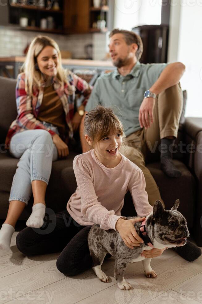 Familie Verbindung Zeit mit spielerisch Französisch Bulldogge Welpe im gemütlich Leben Zimmer foto