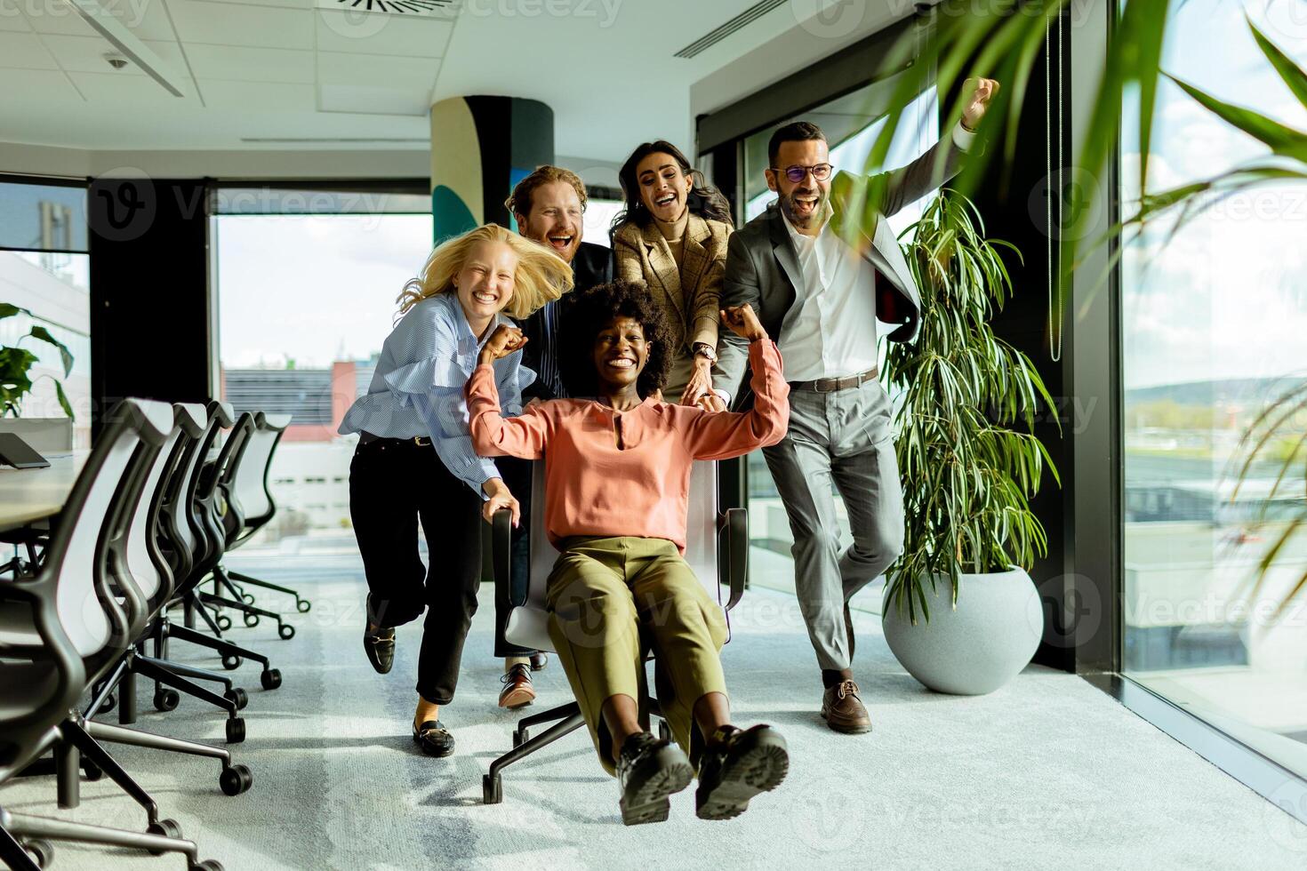 froh Büro Kollegen engagieren im ein spielerisch Stuhl Rennen auf ein sonnig Nachmittag. foto