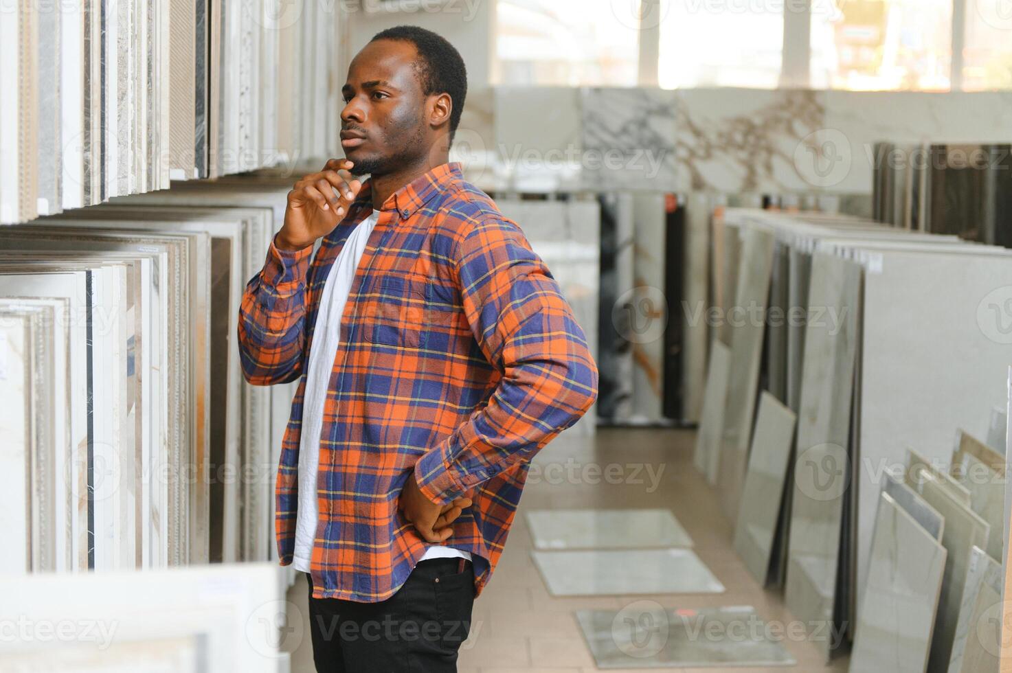 afrikanisch amerikanisch Mann Kunde wählen Keramik Fliese beim Gebäude Materialien Geschäft foto
