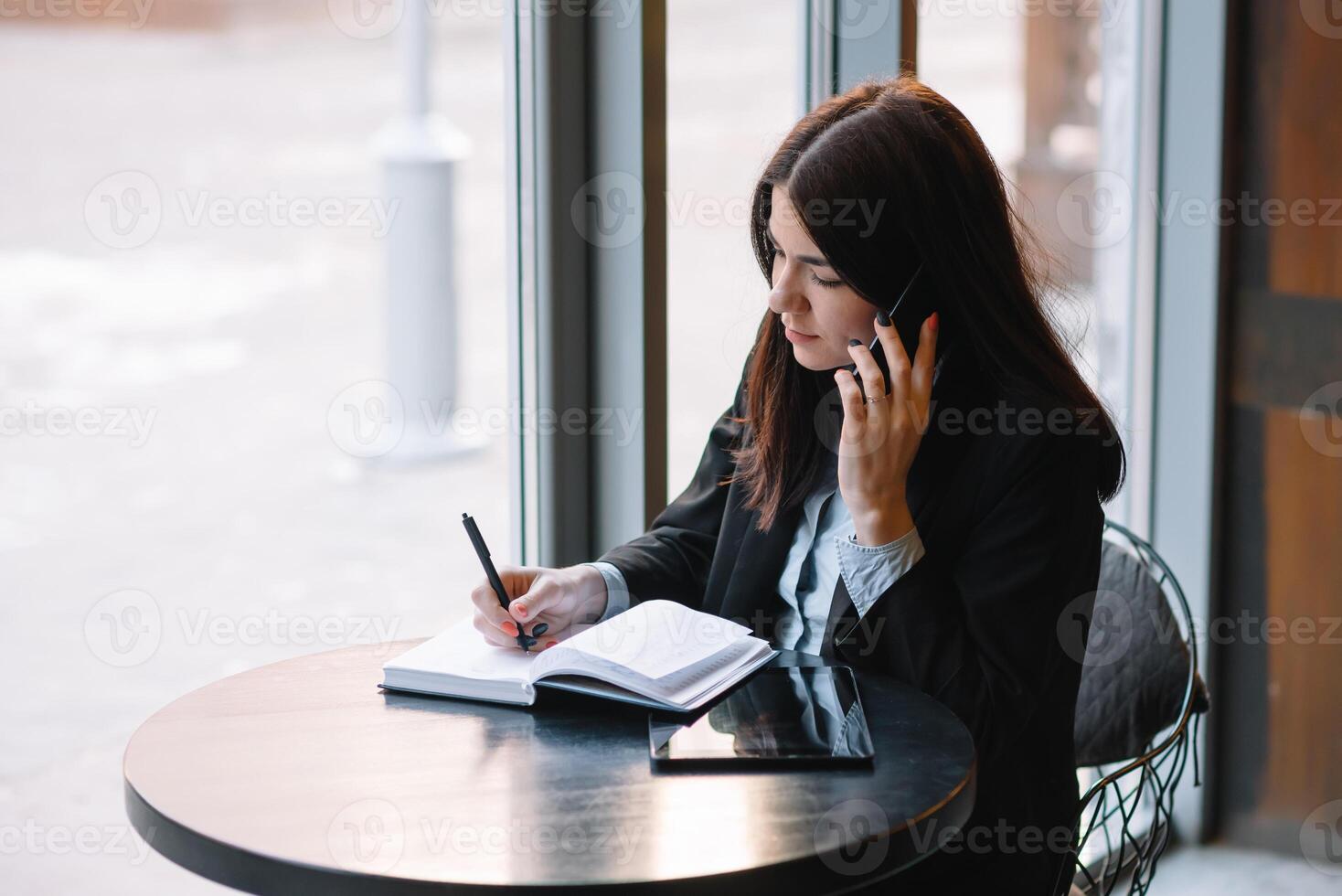 Geschäftsfrau reden auf das Telefon und nehmen Anmerkungen foto