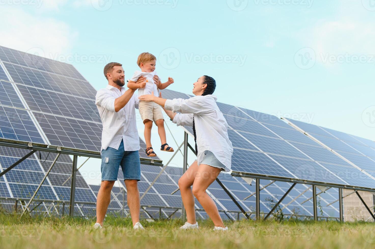 jung Familie von drei ist duckte sich in der Nähe von Photovoltaik Solar- Tafel, wenig Junge und Eltern. modern Familie Konzept. das Konzept von Grün Energie foto