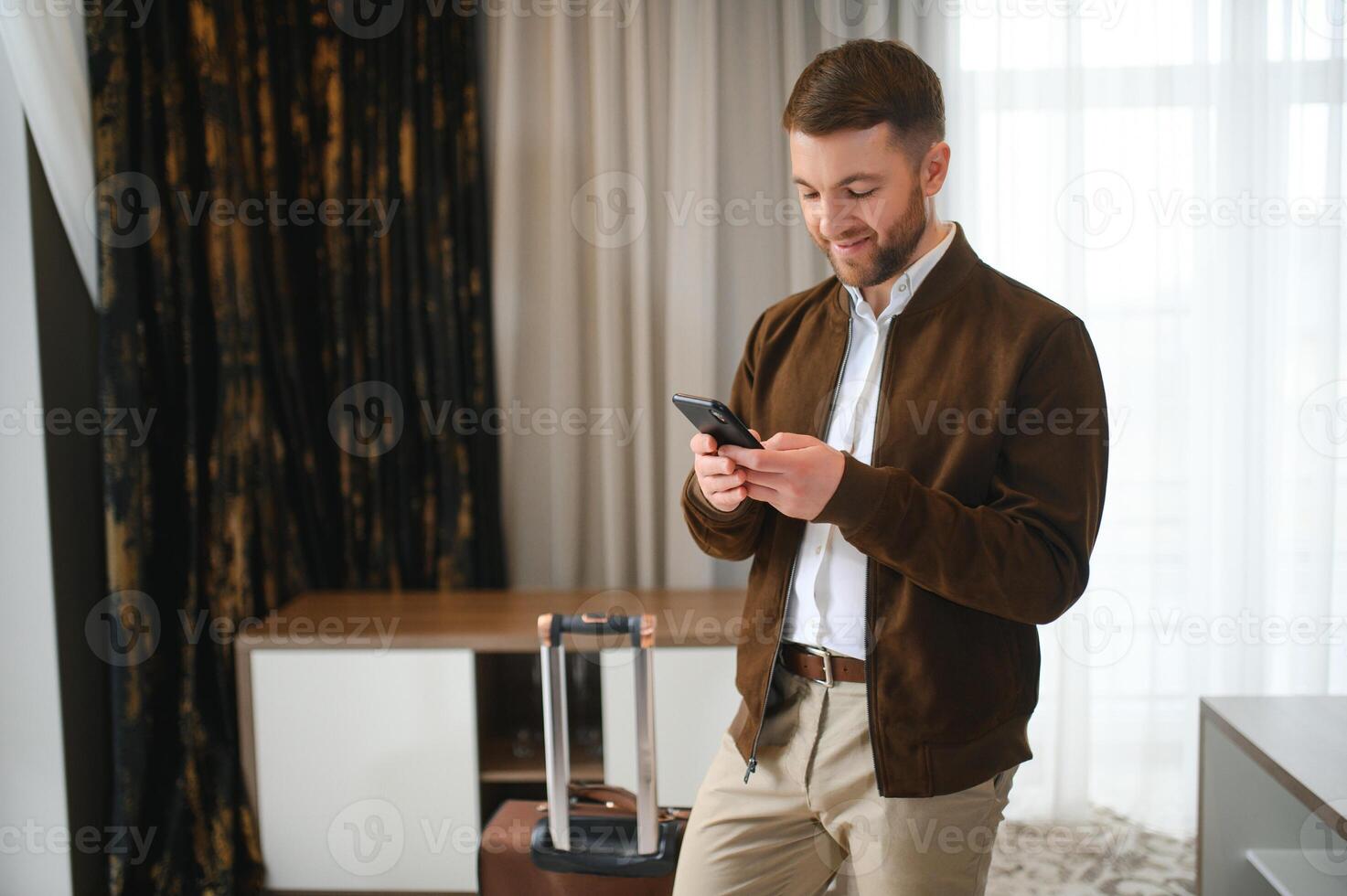 jung Geschäftsmann mit Koffer Stehen beim Hotel Zimmer. Geschäft Ausflug Konzept foto