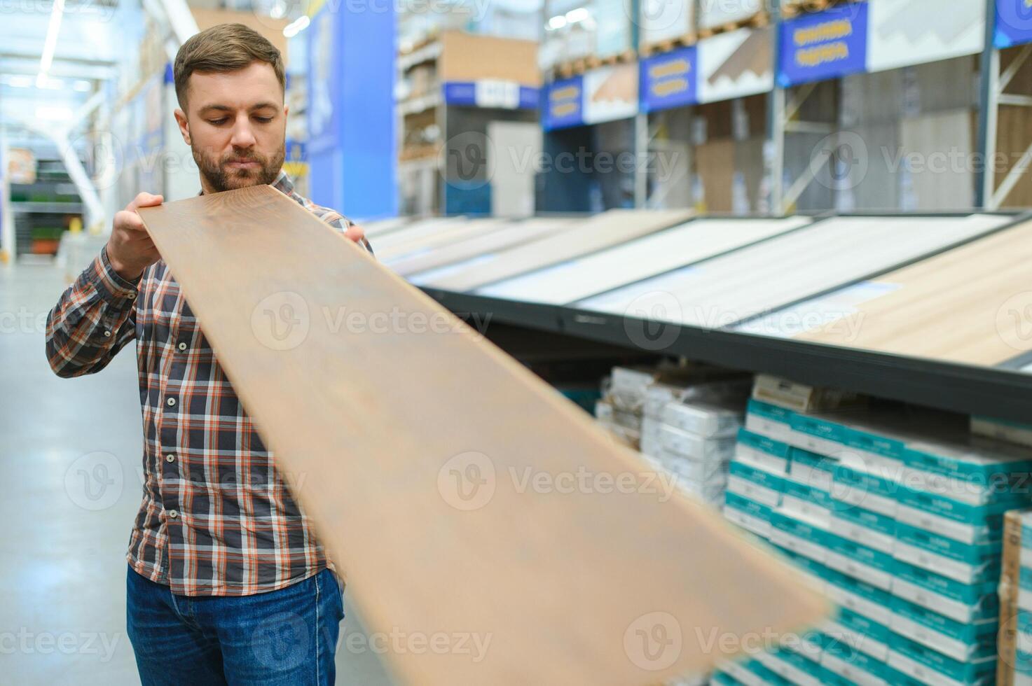 Mann wählen Bodenbelag im Hardware- Geschäft foto