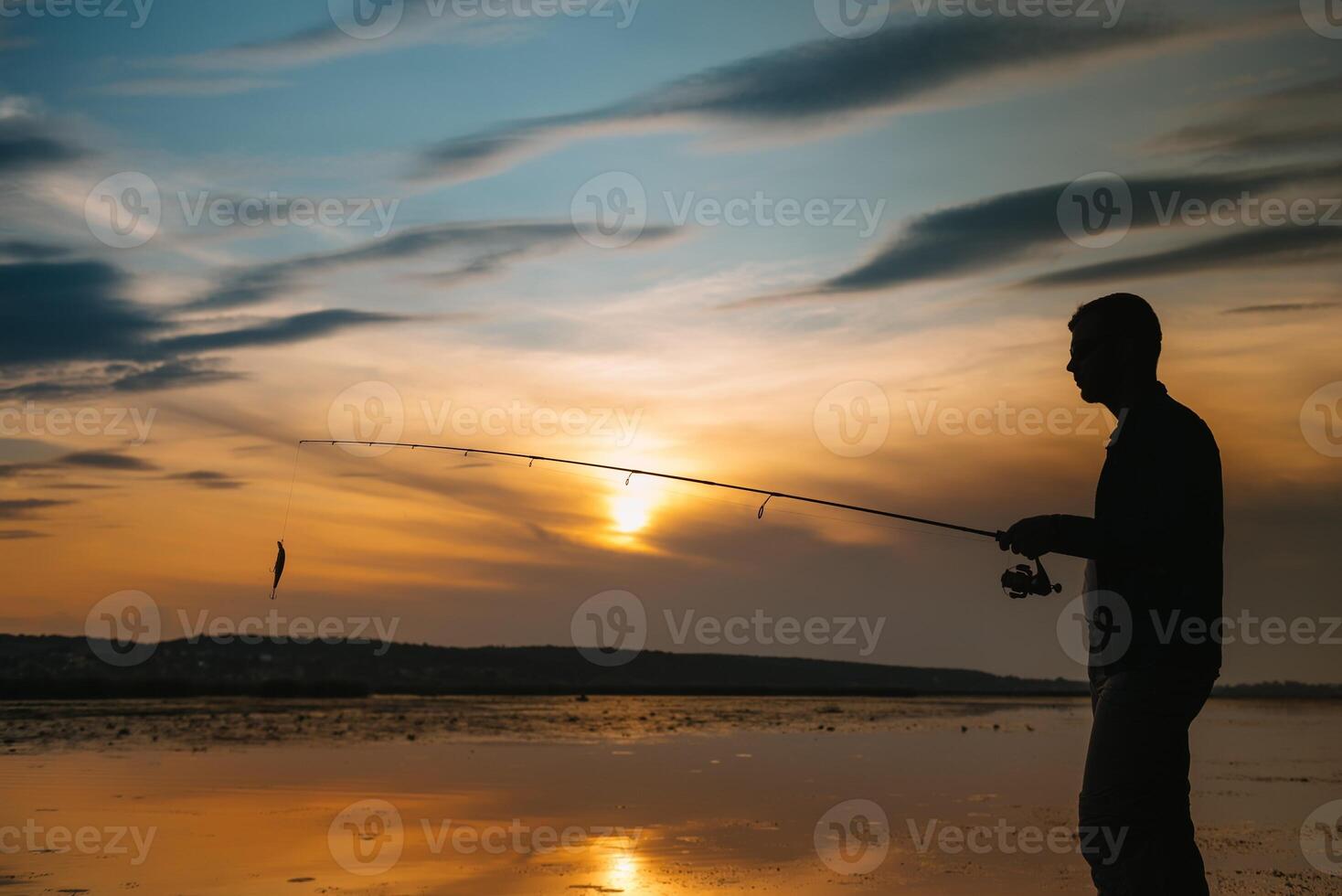 ein Fischer Silhouette Angeln beim Sonnenuntergang. frisches Wasser Angeln, Fang von Fisch. foto