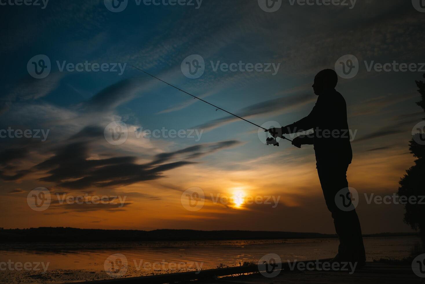 Fischer beim Sonnenuntergang auf das Fluss .Schön Sommer- Landschaft mit Sonnenuntergang auf das Fluss. Angeln. Spinnen beim Sonnenuntergang. Silhouette von ein Fischer. foto