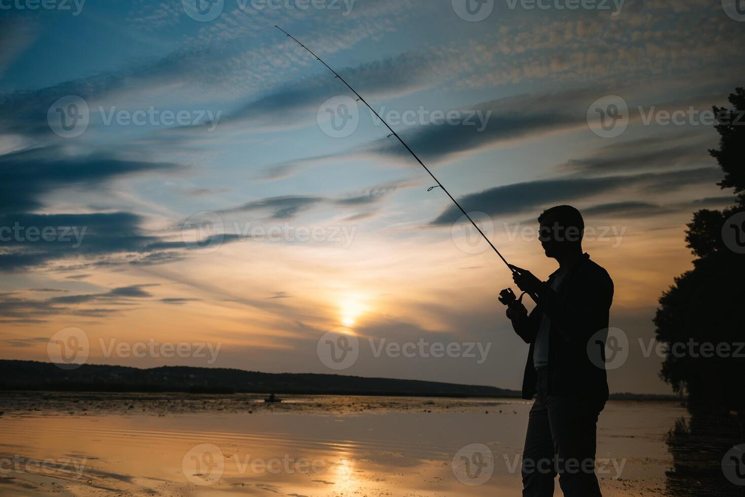 Angeln. Spinnen beim Sonnenuntergang. Silhouette von ein Fischer. foto