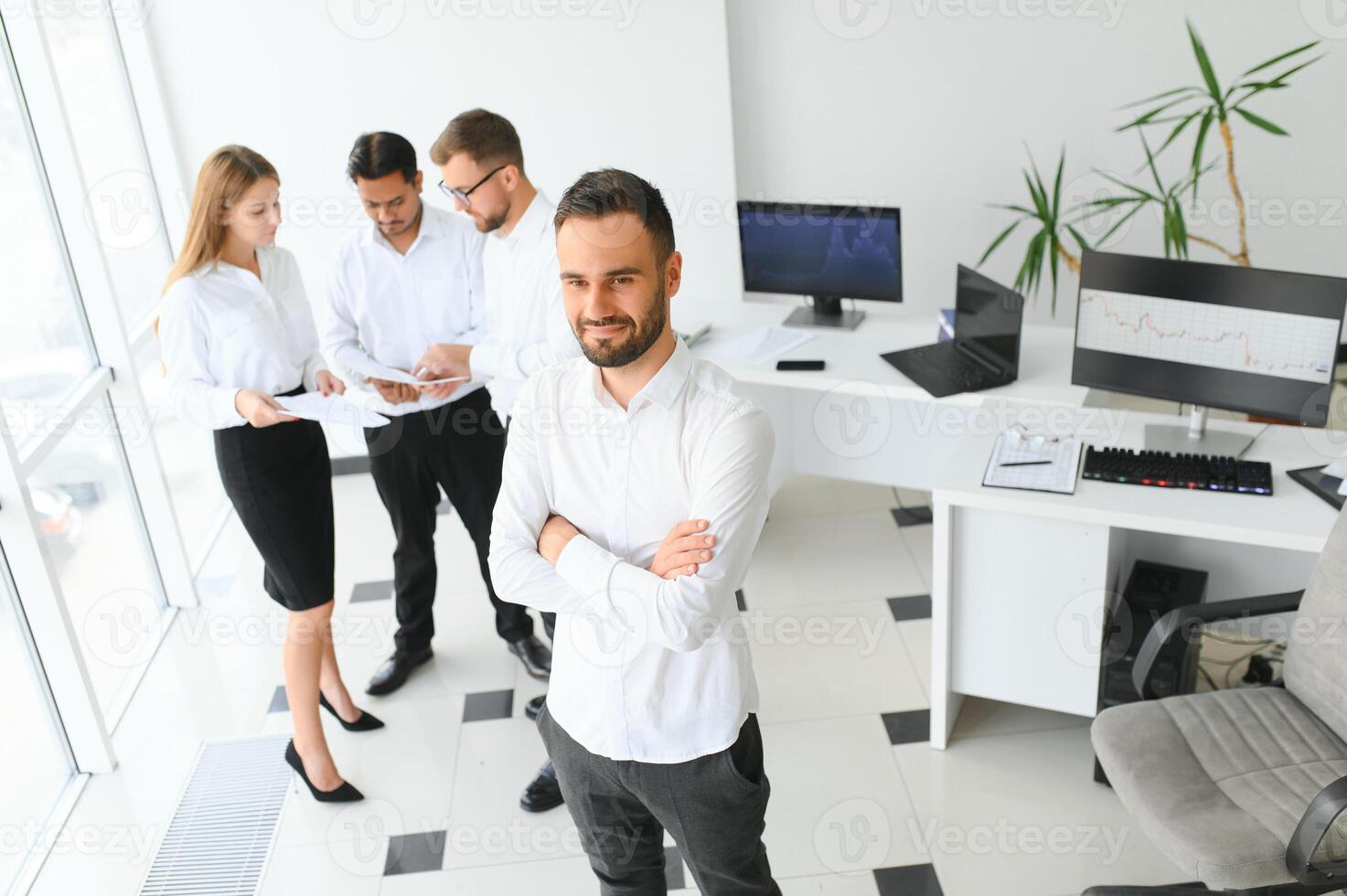 Porträt von jung gut aussehend Geschäftsmann im Büro mit Kollegen im das Hintergrund foto