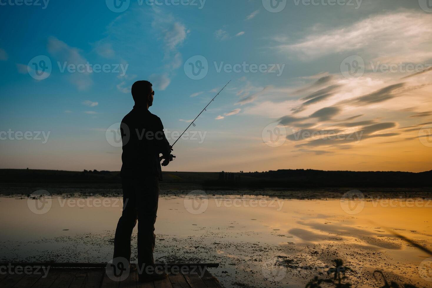 ein Fischer Silhouette Angeln beim Sonnenuntergang. frisches Wasser Angeln, Fang von Fisch. foto