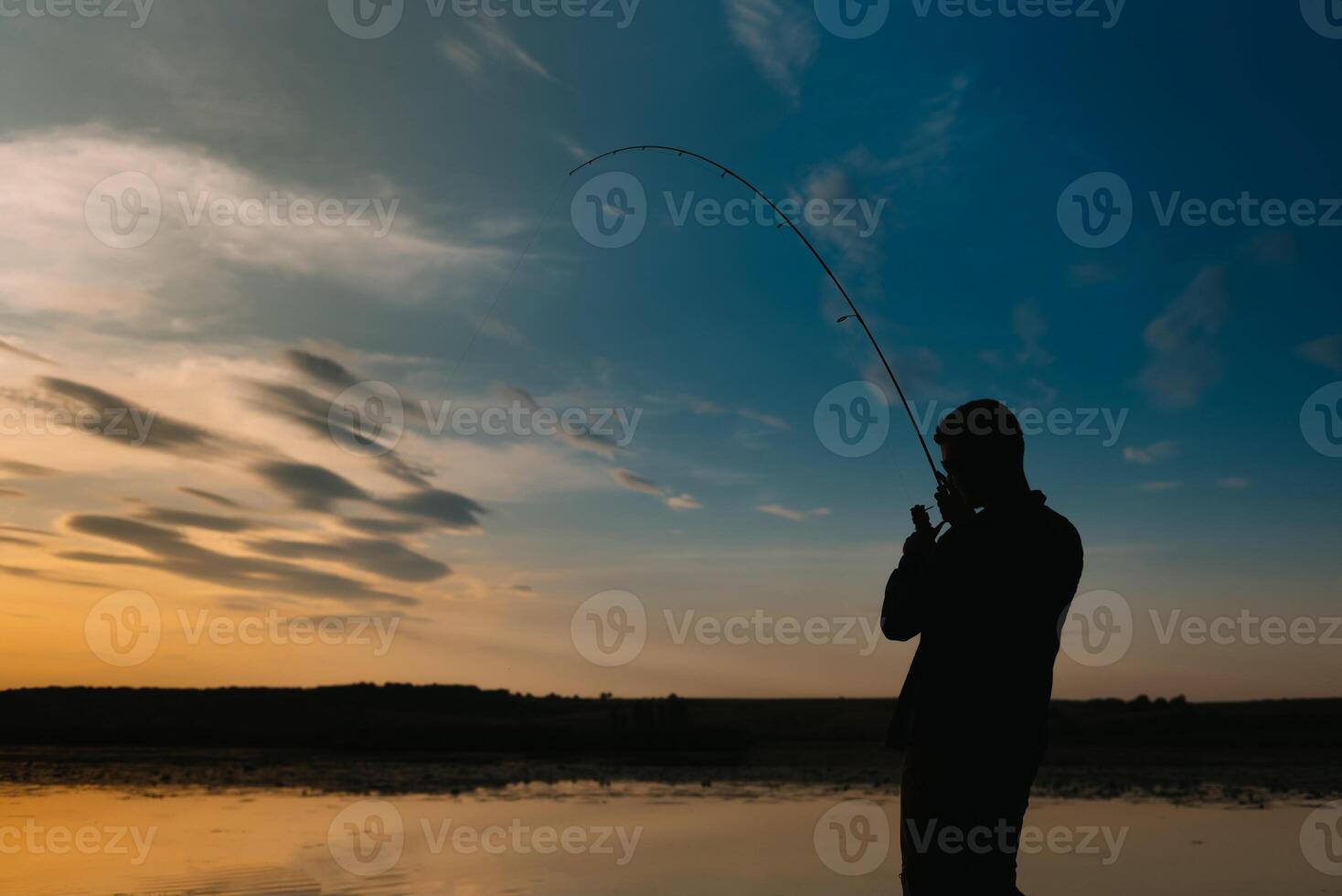 Fischer beim Sonnenuntergang auf das Fluss .Schön Sommer- Landschaft mit Sonnenuntergang auf das Fluss. Angeln. Spinnen beim Sonnenuntergang. Silhouette von ein Fischer. foto