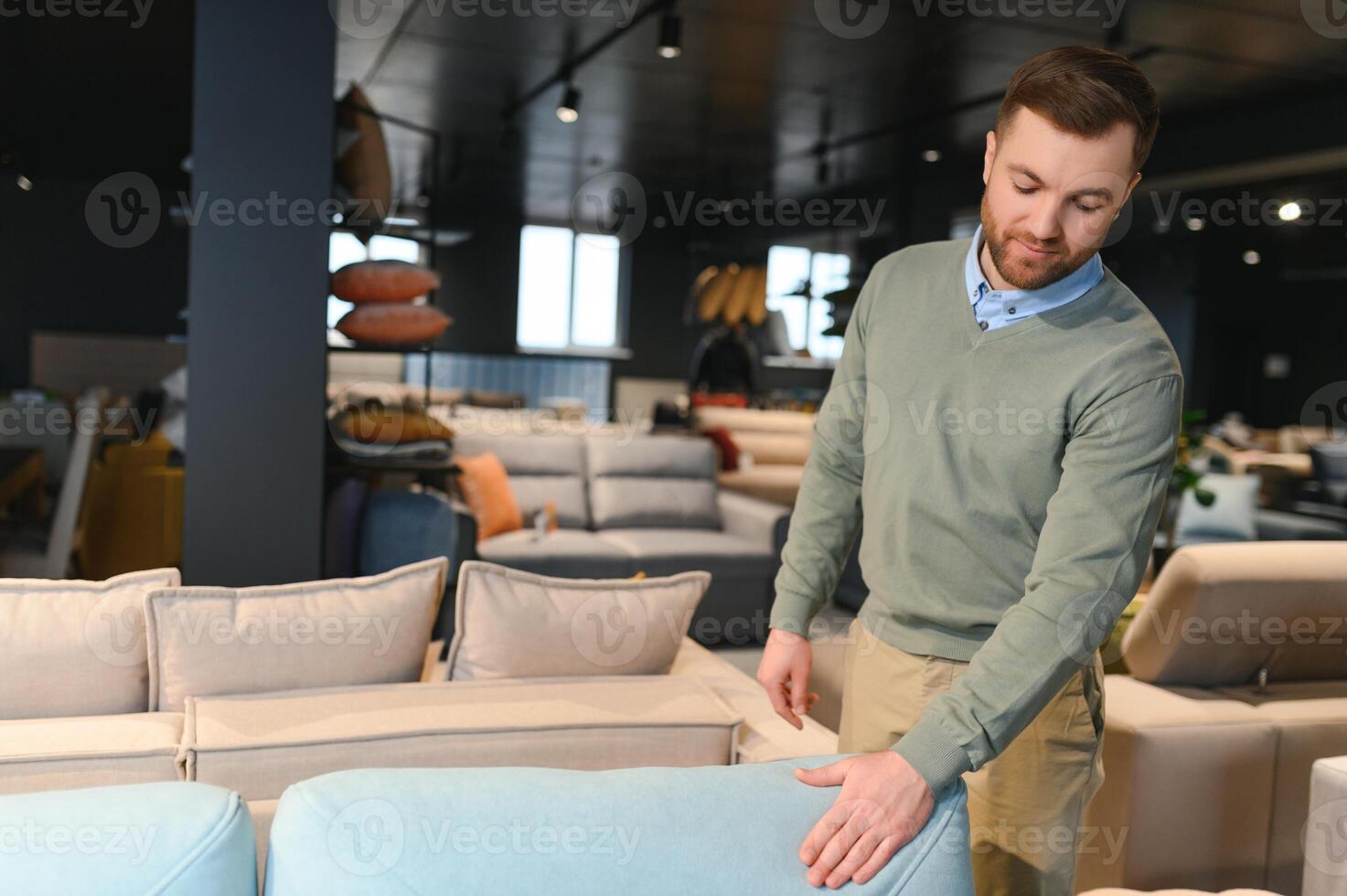 jung Mann Kauf Sofa im Möbel Geschäft foto