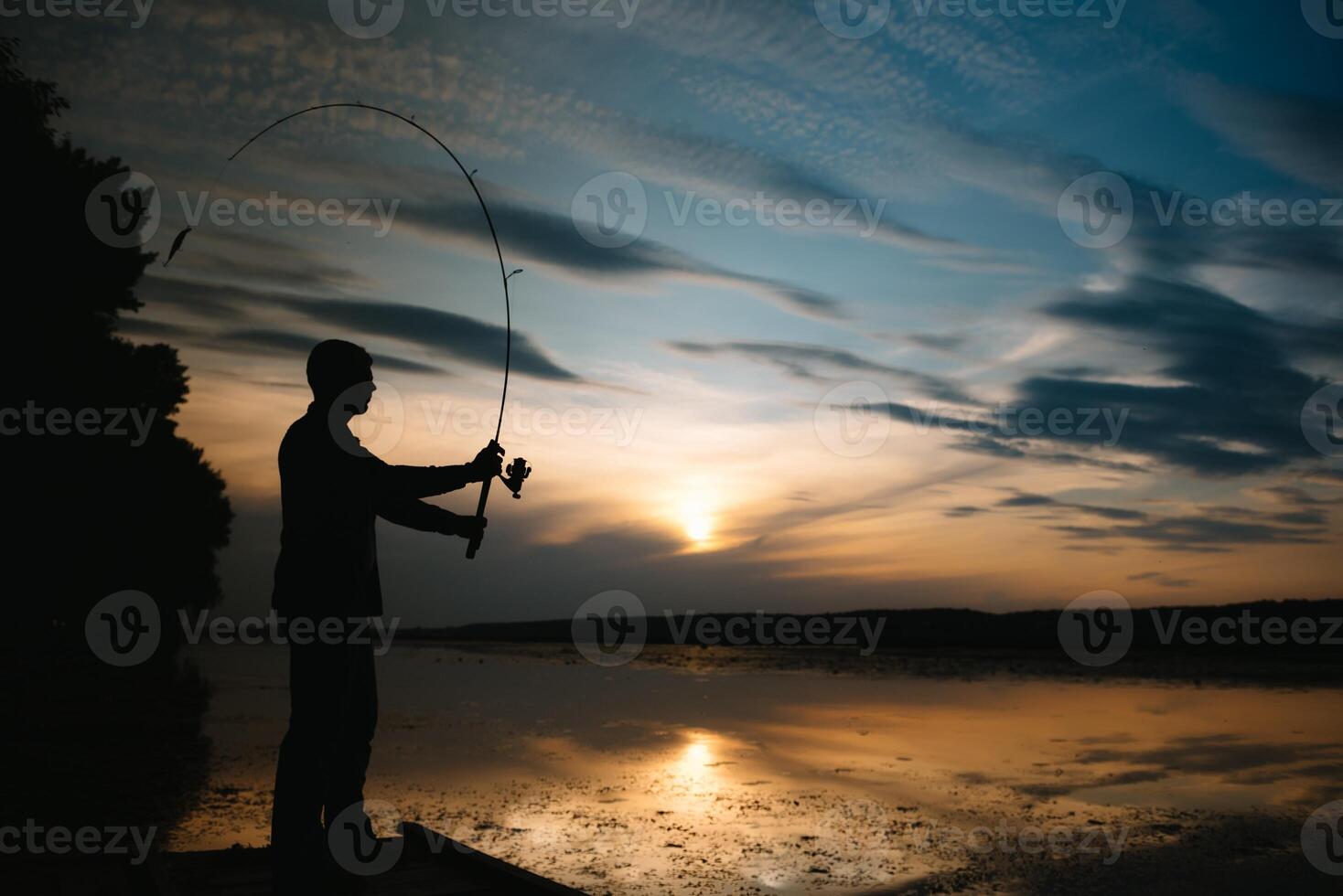 Fischer beim Sonnenuntergang auf das Fluss .Schön Sommer- Landschaft mit Sonnenuntergang auf das Fluss. Angeln. Spinnen beim Sonnenuntergang. Silhouette von ein Fischer foto