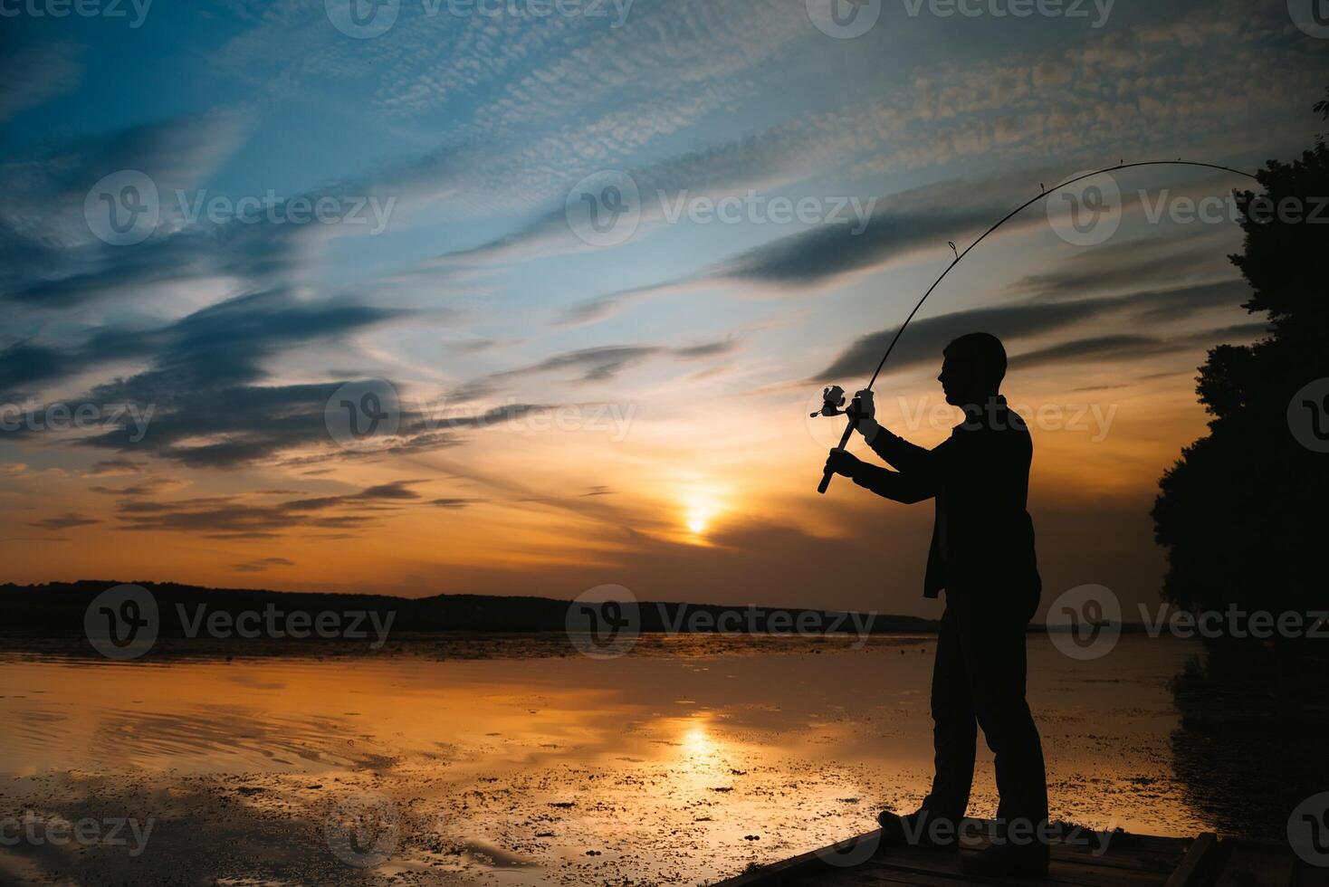 Angeln. Spinnen beim Sonnenuntergang. Silhouette von ein Fischer foto