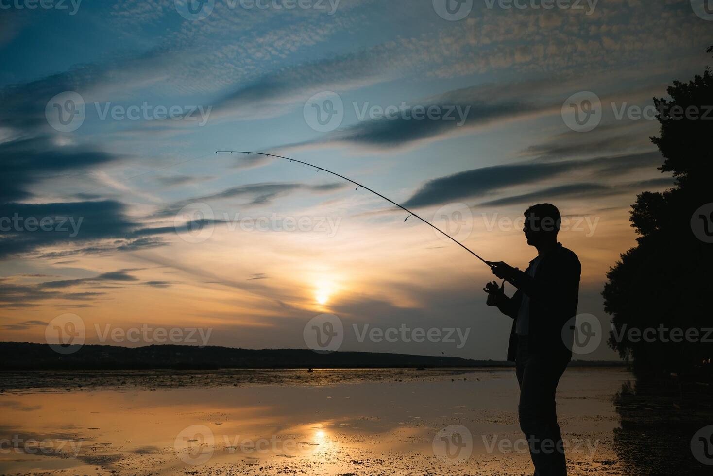 Angeln. Spinnen beim Sonnenuntergang. Silhouette von ein Fischer. foto