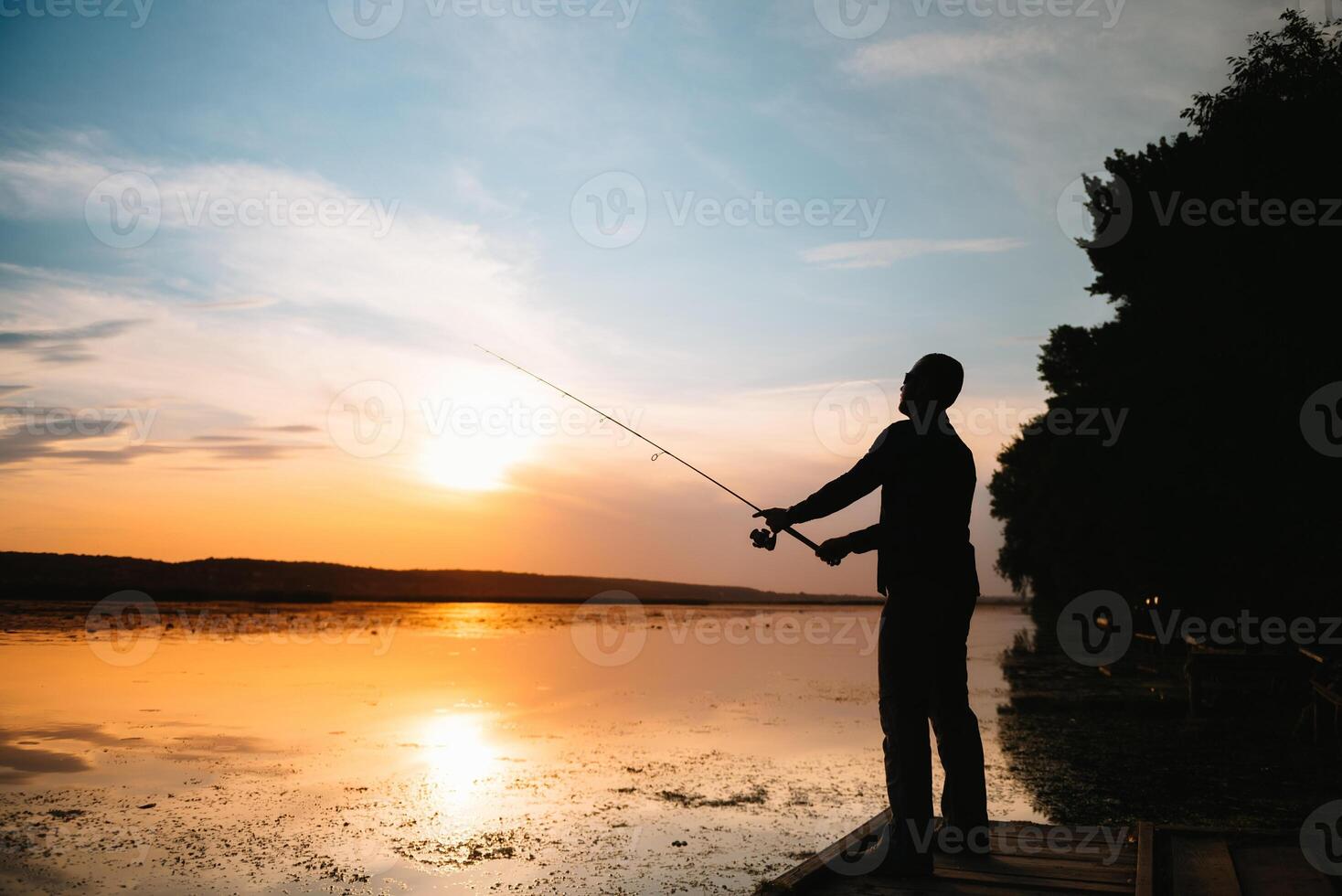 Angeln. Spinnen beim Sonnenuntergang. Silhouette von ein Fischer. foto