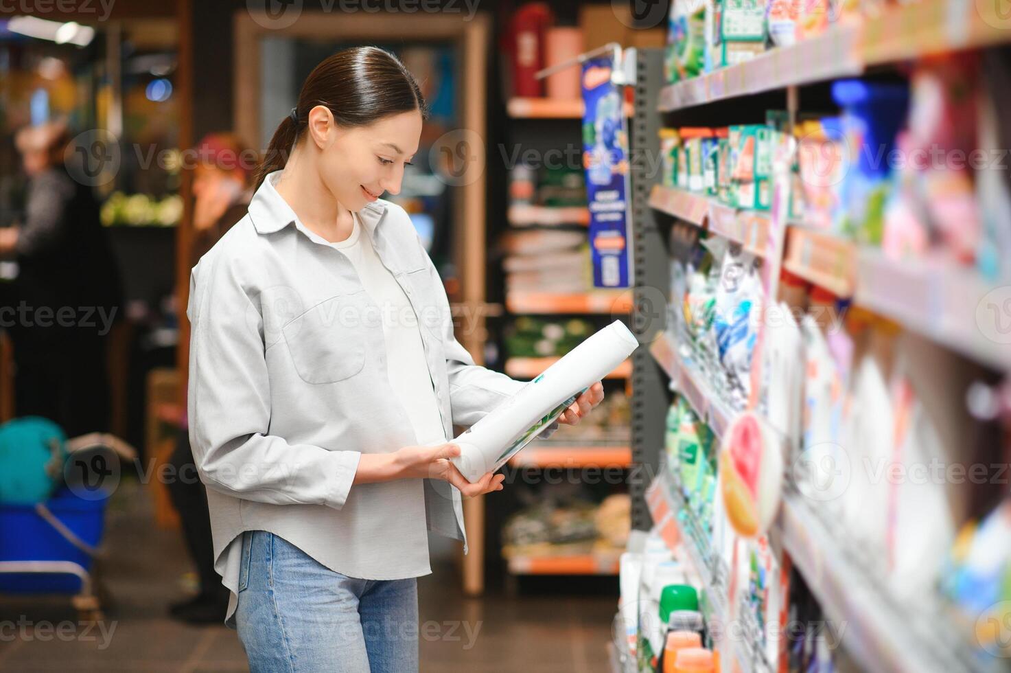 interessiert jung Frau Herstellung Einkäufe im Haushalt Chemikalien speichern, lesen Etiketten auf Flaschen foto