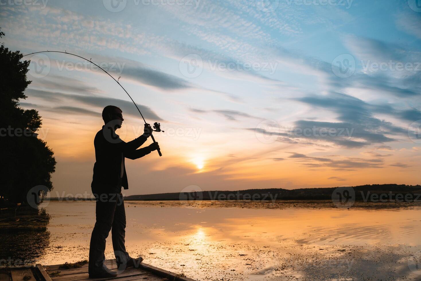 ein Fischer Silhouette Angeln beim Sonnenuntergang. frisches Wasser Angeln, Fang von Fisch. foto