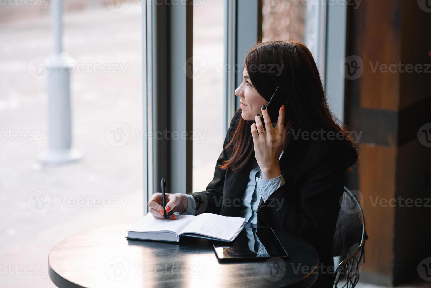 Geschäftsfrau reden auf das Telefon und nehmen Anmerkungen foto