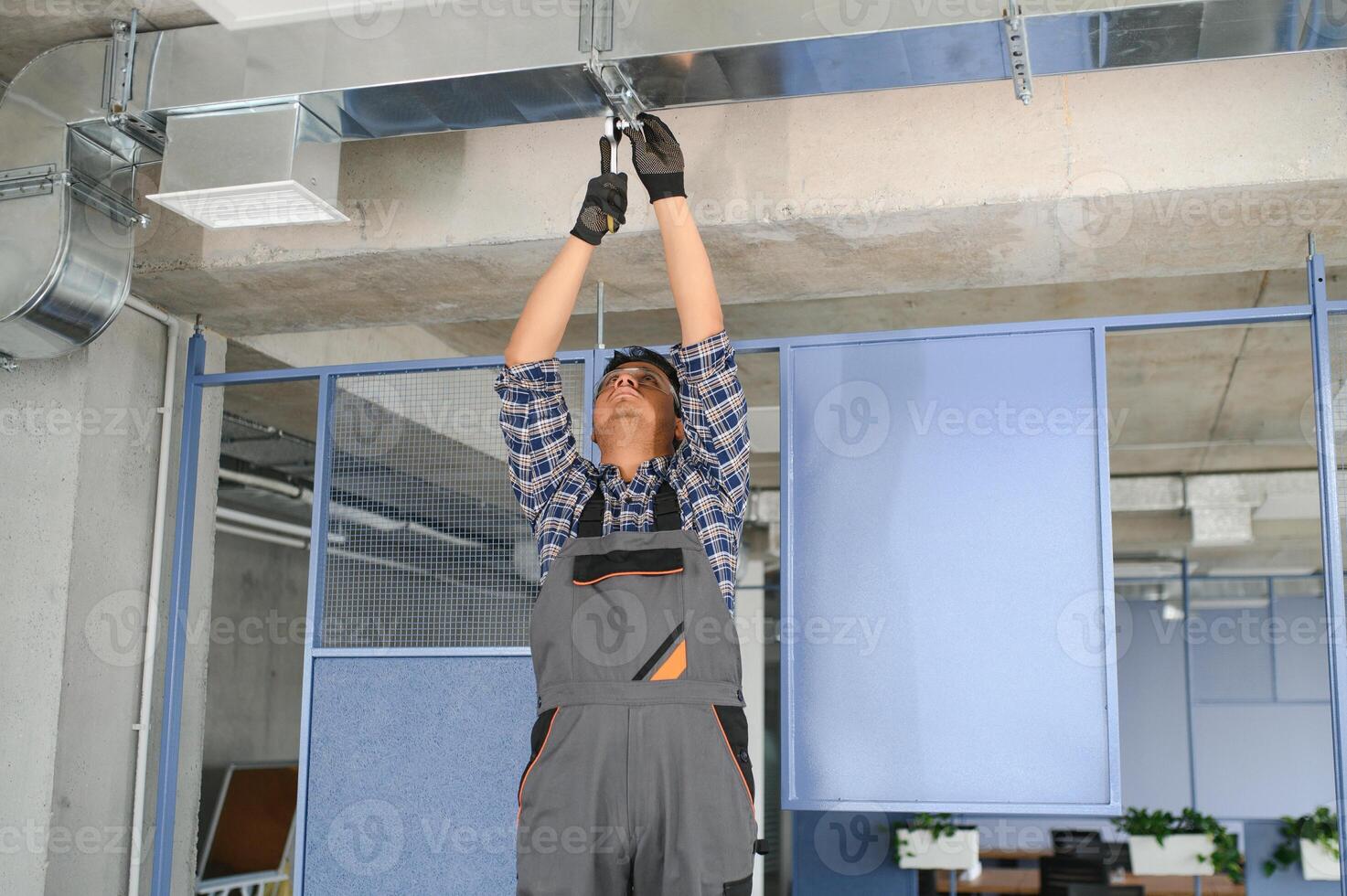 hvac indisch Arbeiter Installieren geleitet Rohr System zum Belüftung und Luft Konditionierung. Kopieren Raum foto