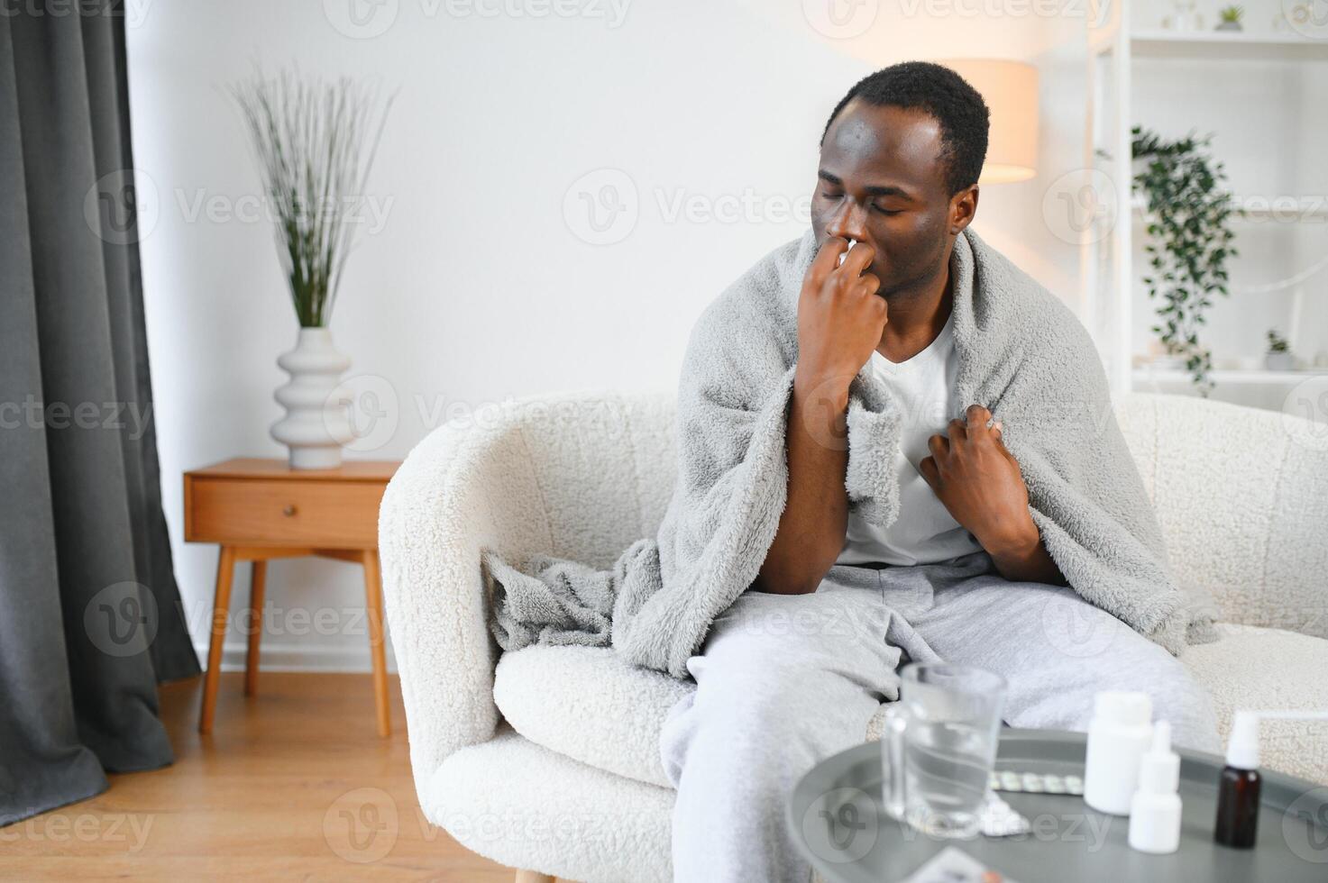 kalt und Grippe Behandlung. krank afrikanisch amerikanisch Mann mit Nasal- sprühen foto