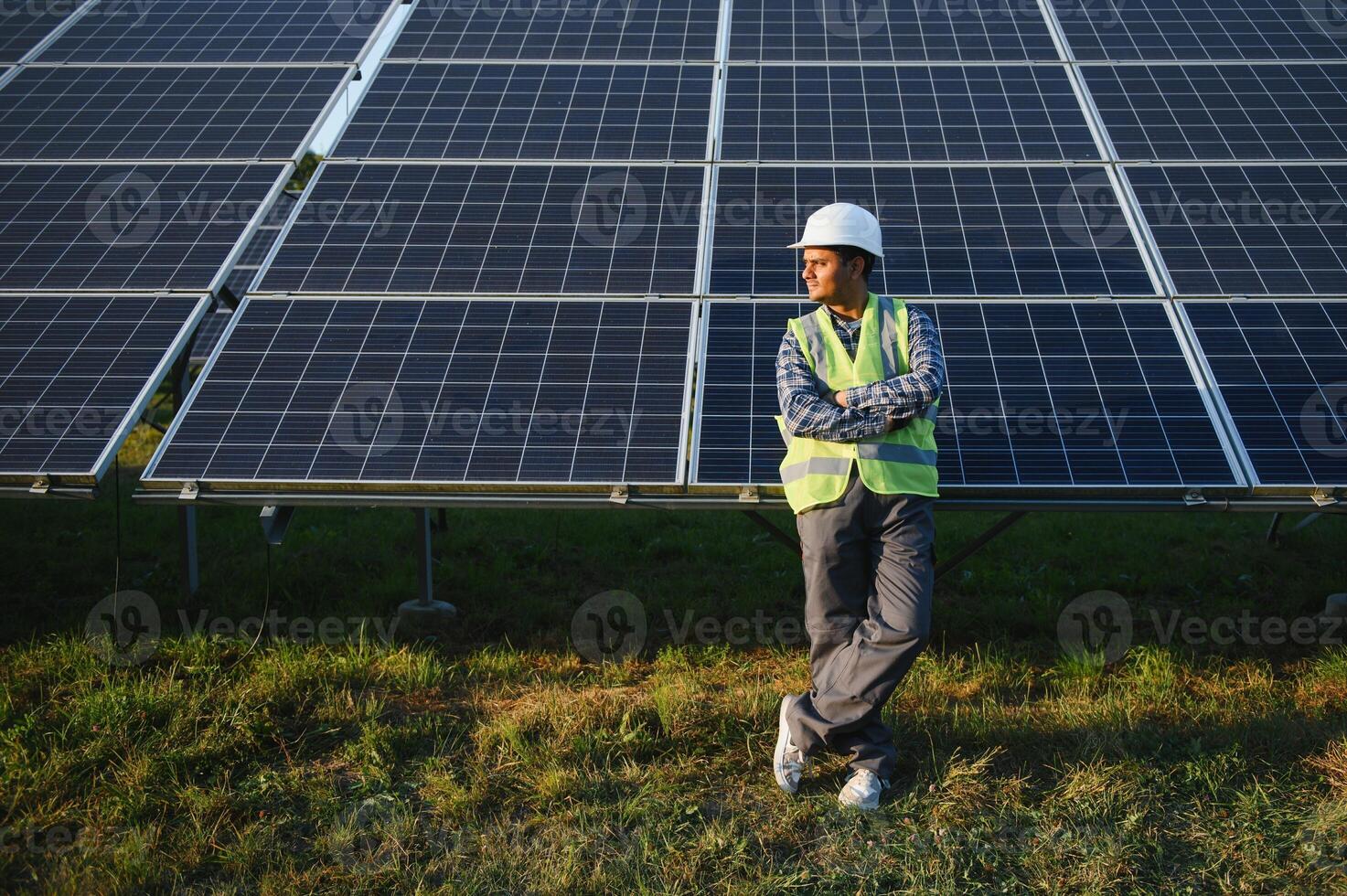 indisch Mann im Uniform auf Solar- Bauernhof. kompetent Energie Ingenieur steuern Arbeit von Photovoltaik Zellen foto