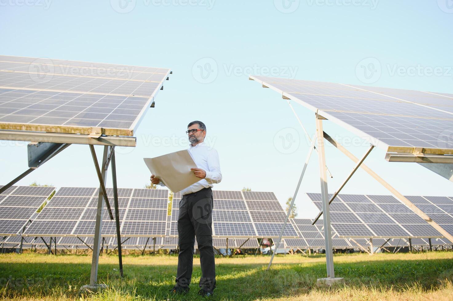 Solar- Leistung Pflanze. Mann Stehen in der Nähe von Solar- Tafeln. verlängerbar Energie foto