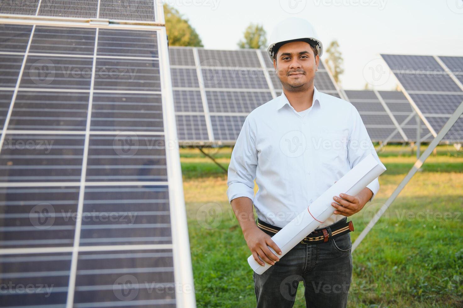ein indisch männlich Ingenieur Arbeiten auf ein Feld von Solar- Tafeln. das Konzept von verlängerbar Energie foto