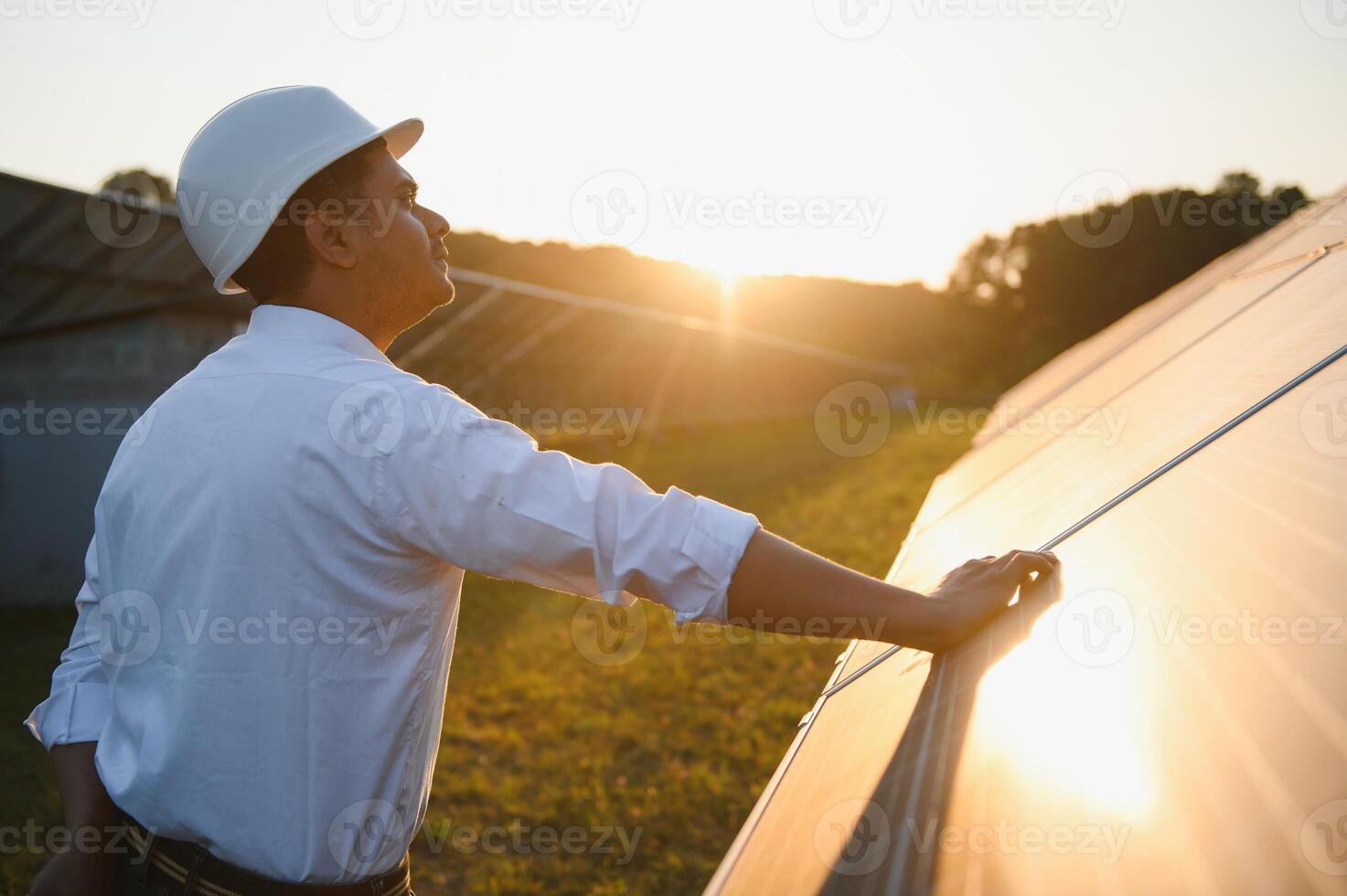 Porträt von ein jung indisch männlich Ingenieur oder Architekt beim ein Solar- Panel Bauernhof. das Konzept von sauber Energie foto