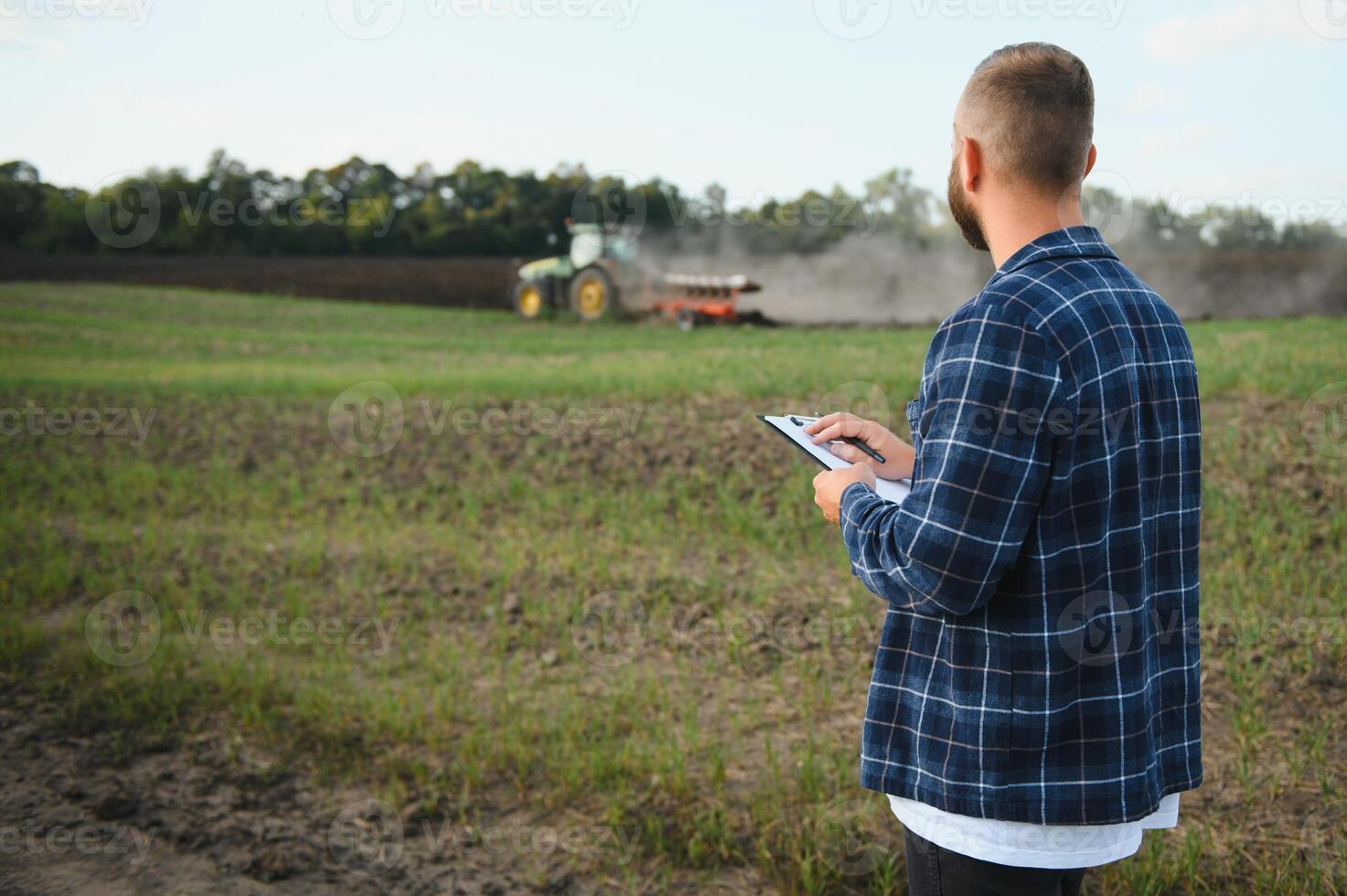 Farmer Arbeiten auf Feld im modern Landwirtschaft - - Traktor Hintergrund. foto