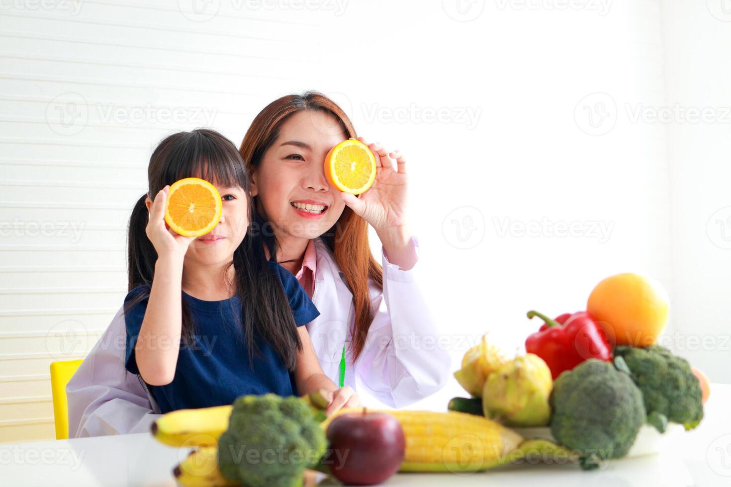 Ernährung zum Schulalter Kinder. ein schön Ernährungsberater oder Arzt mit ein wenig Mädchen halten ein orange. wählen das richtig Essen gemäß zu das Alter von das Kind zum gut Gesundheit foto