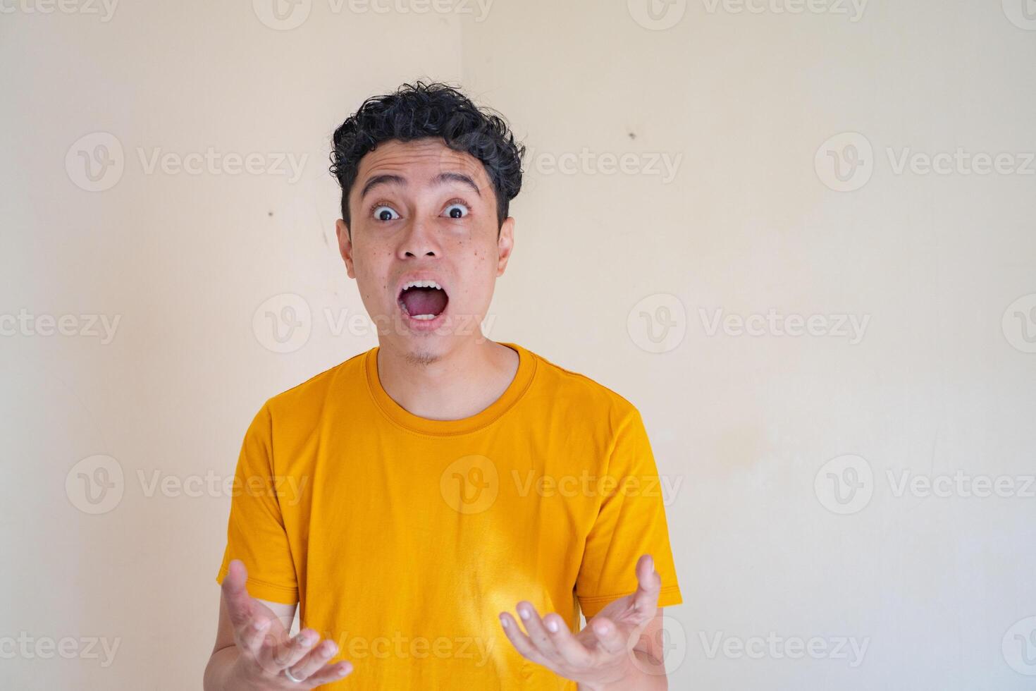 jung Mann tragen Gelb T-Shirt mit überrascht Pose Ausdruck Geste. das Foto ist geeignet zu verwenden zum Mann Ausdruck Werbung und Mode Leben Stil.
