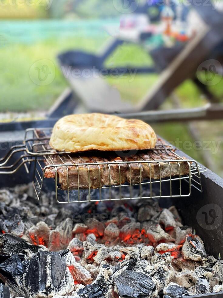 draussen Grill. Fleisch und Pita-Brot Brot auf ein Grill Über heiß Kohlen foto