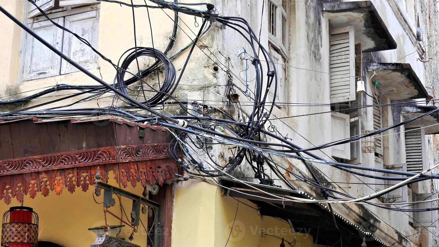 ein verheddert Chaos von Kabel auf das draußen von ein Haus foto