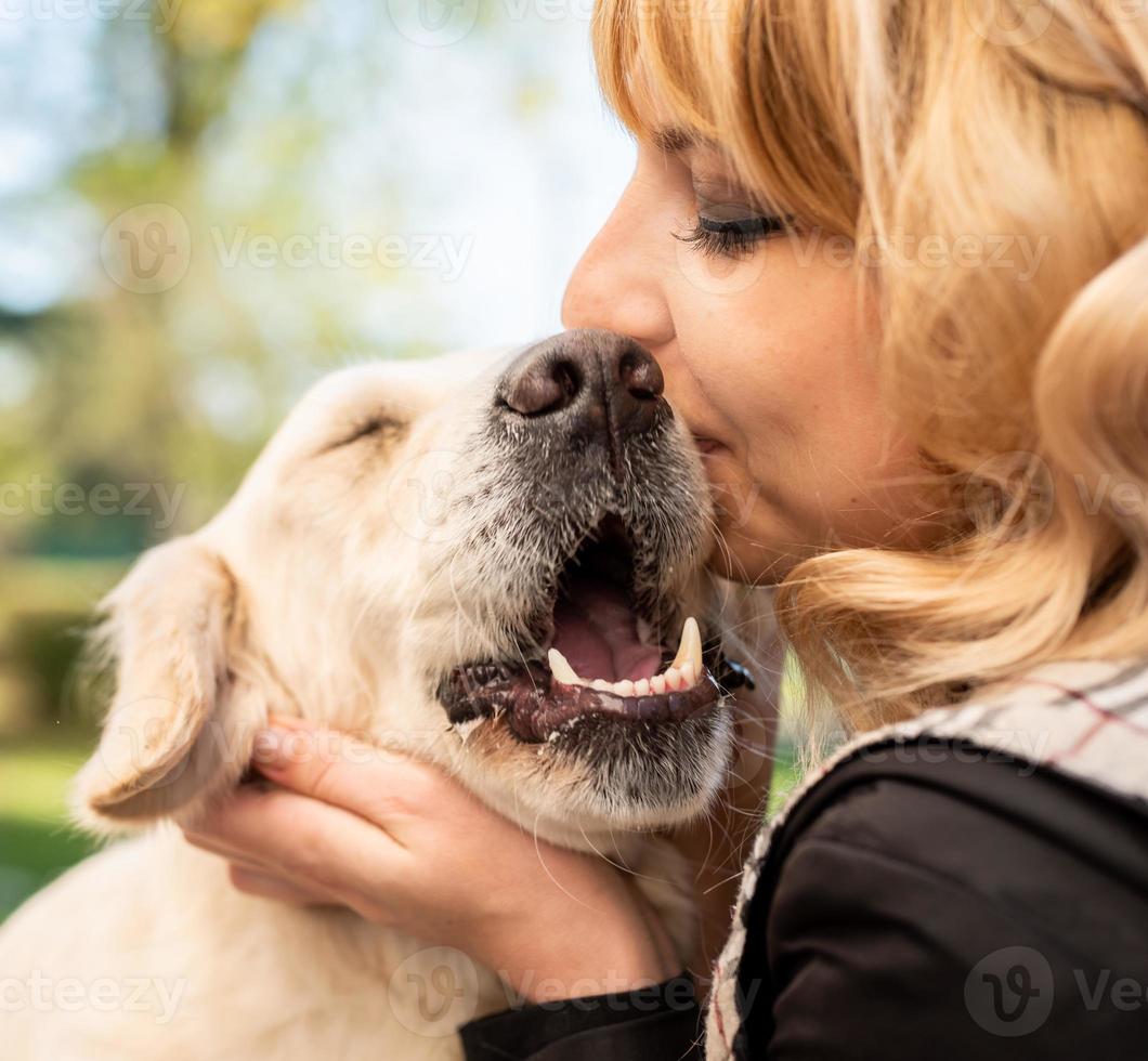 blonde Frau umarmt ihren Retriever-Hund foto