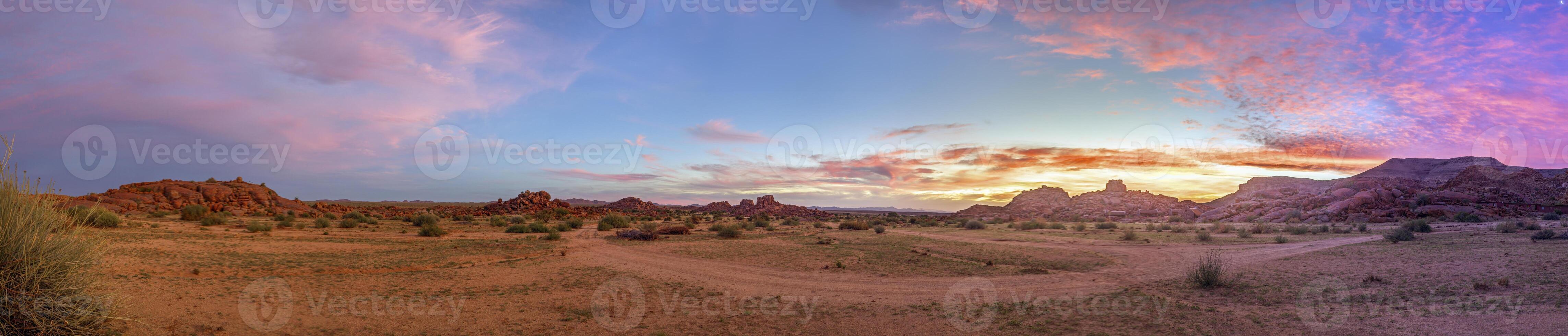 Panorama- Bild von ein bunt Sonnenuntergang Über das veld im Süd- Namibia mit ein Rosa abspielen von Farben foto