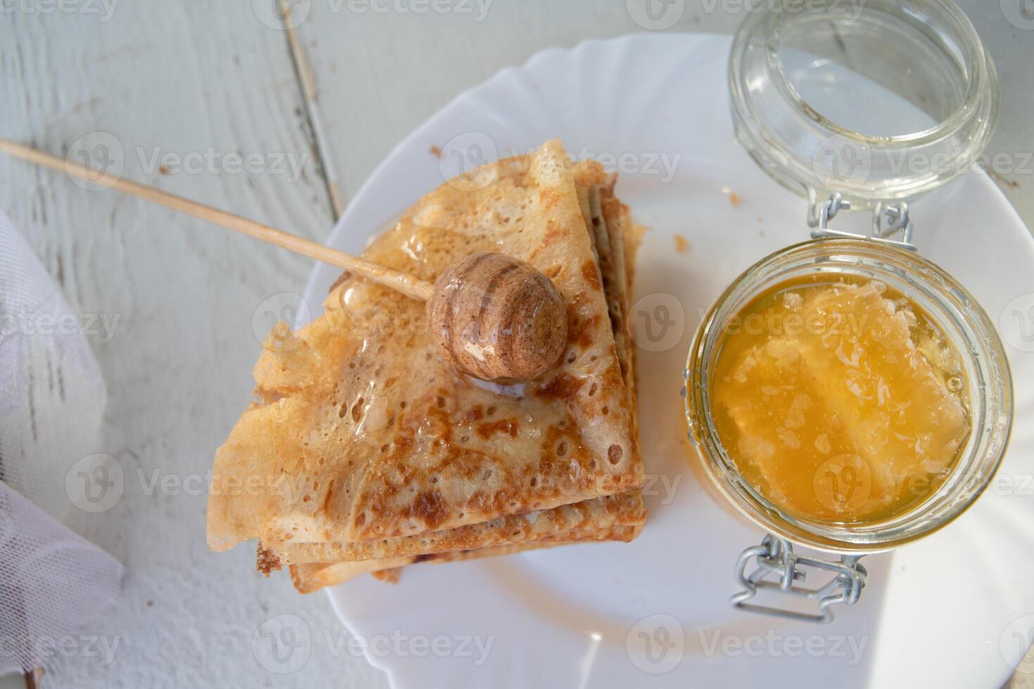 Russisch Pfannkuchen mit Honig und ein Tasse von Tee von ein Jahrgang Samowar maslenitsa Festival Konzept foto