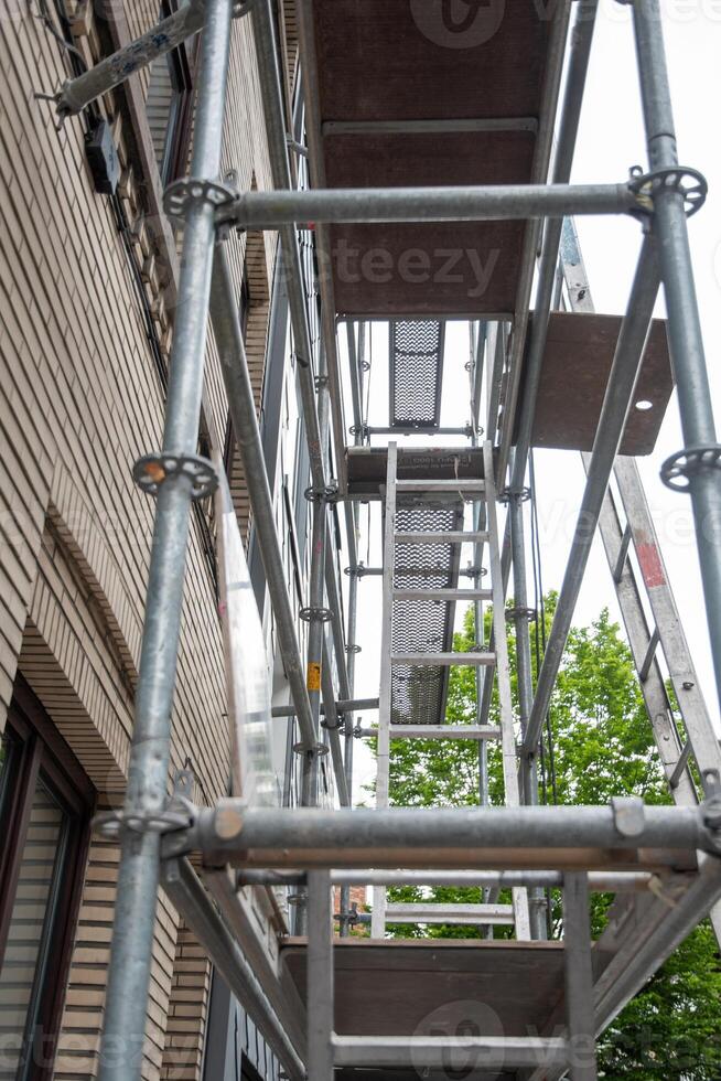 Konstruktion von Stahl Gerüst in der Nähe von Gebäude zum Renovierung Arbeit, vertikal Gerüst Formen verschiedene Gitter, modern foto