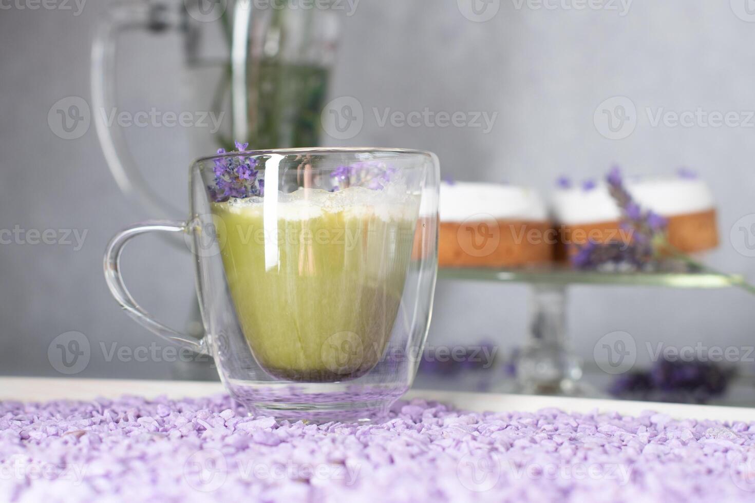 Matcha Grün Tee mit Mousse Kuchen auf ein Tabelle dekoriert mit Lavendel Blumen foto